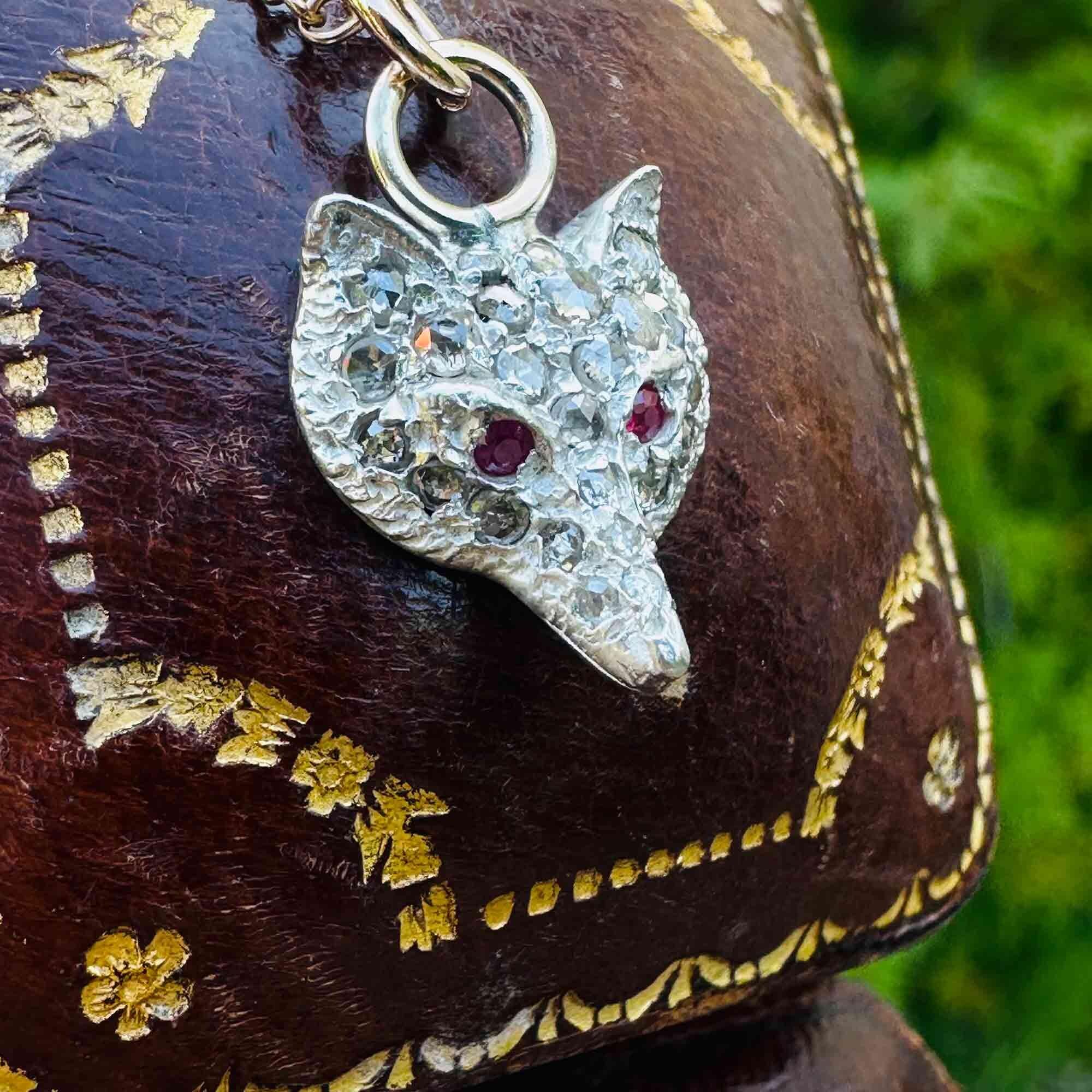 side view of Vintage Fox Head Pendant: Rose Cut Diamonds, Ruby Eyes, Silver & 9ct Rose Gold with antique box in the background