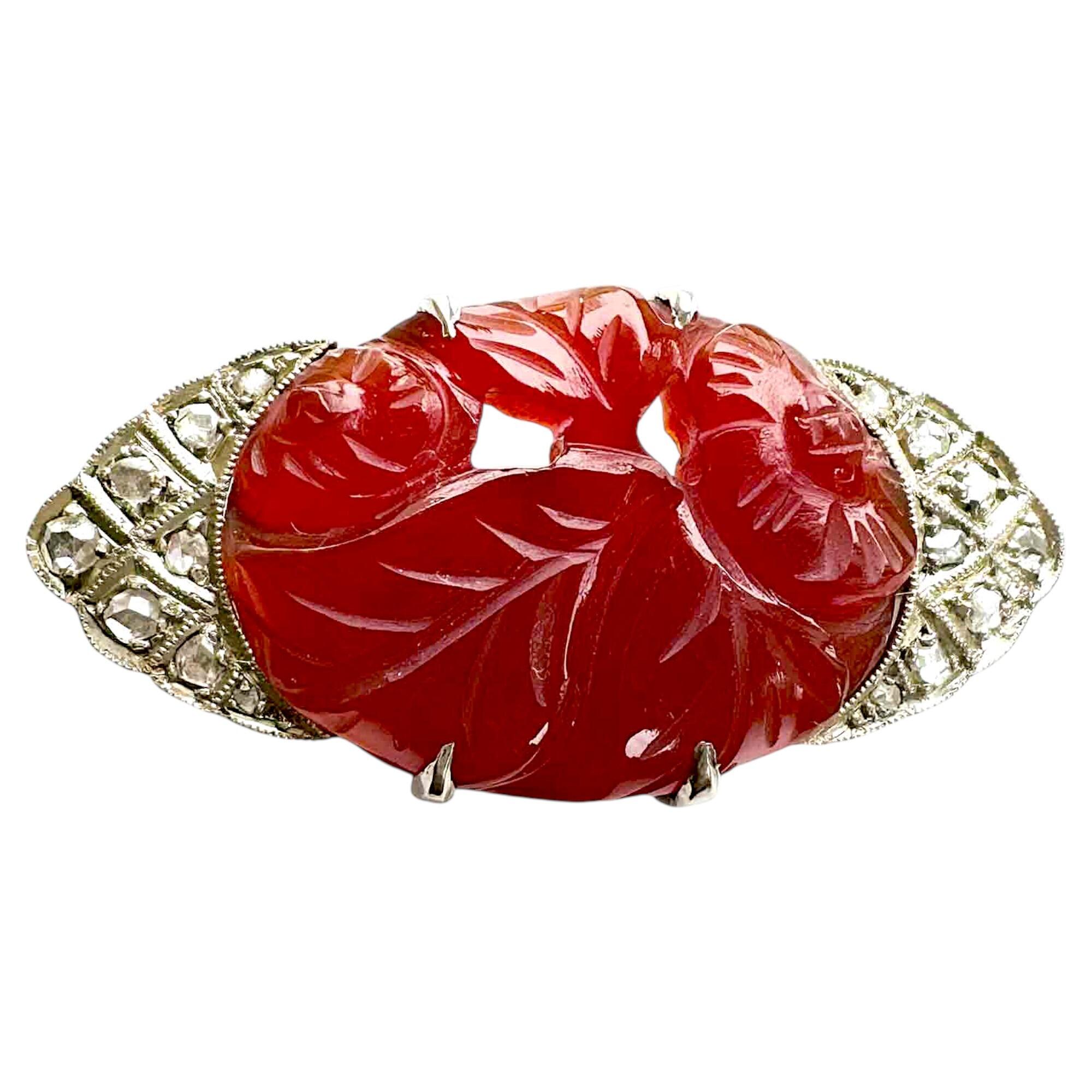 Art Deco brooch with oval carved carnelian stone in gold setting with diamond accents