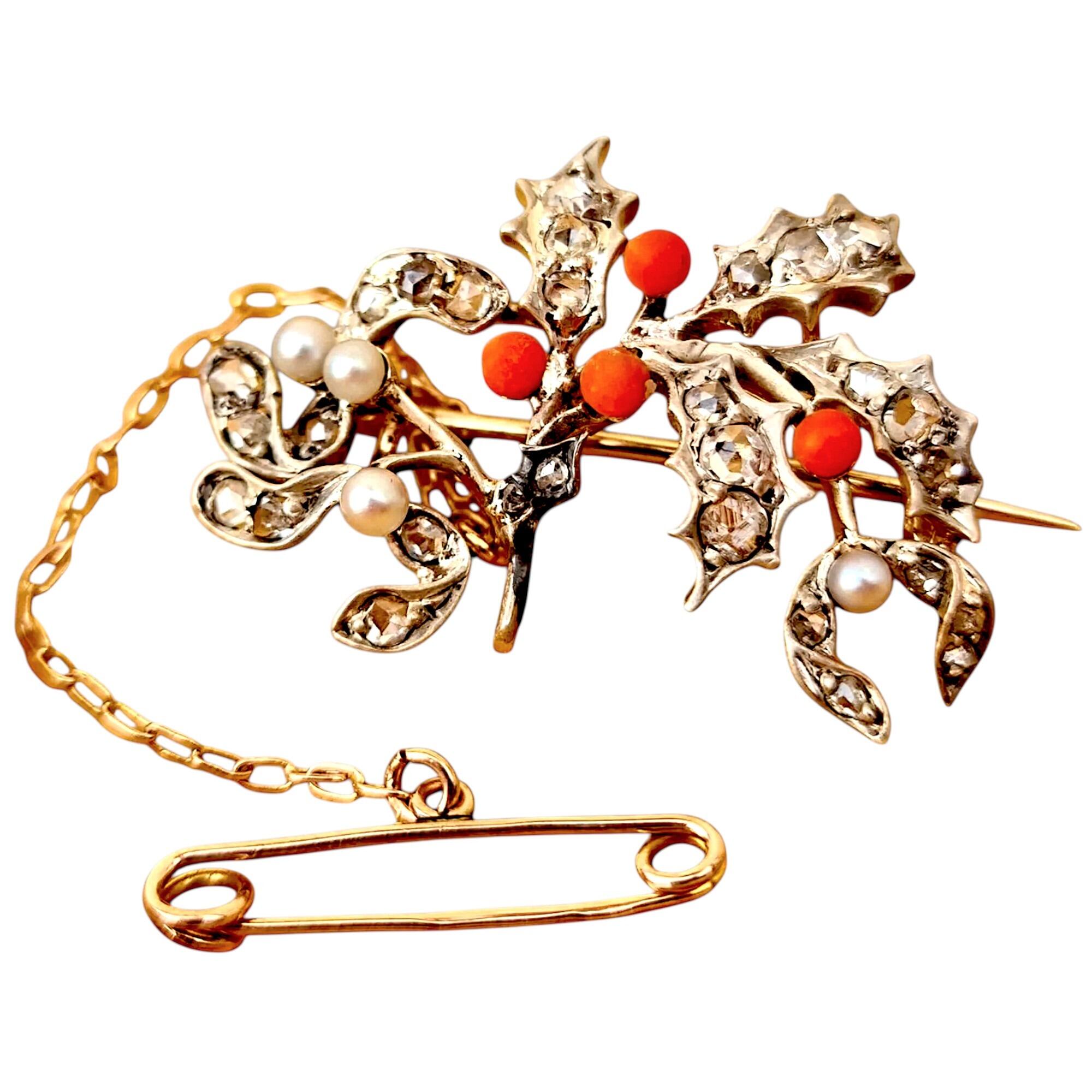 Victorian Christmas holly and mistletoe silver brooch studded with vari-cut diamonds, coral and pearl with 9ct yellow gold safety chain and pin