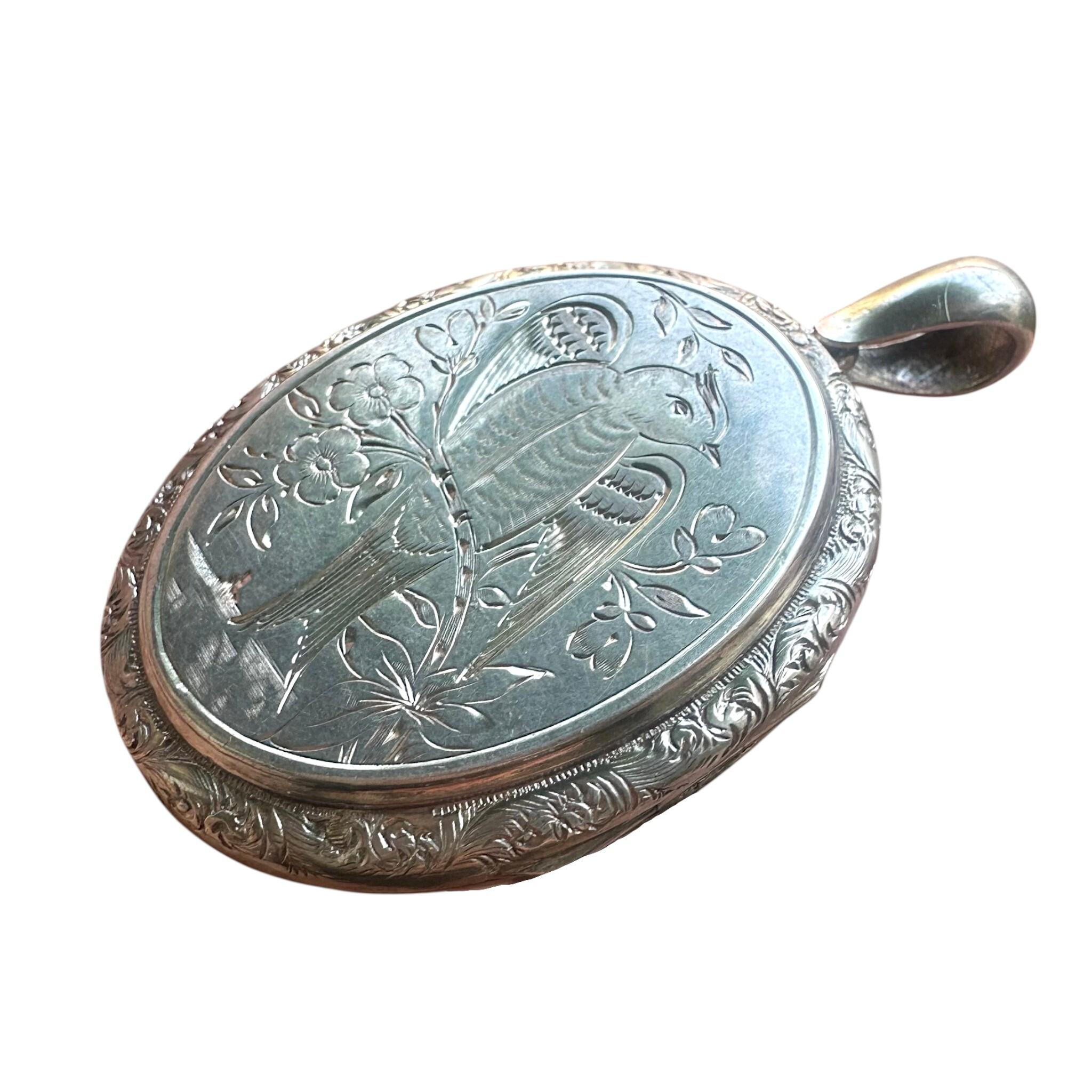 side view of Antique Victorian Silver Engraved Bird Locket Pendant with white background
