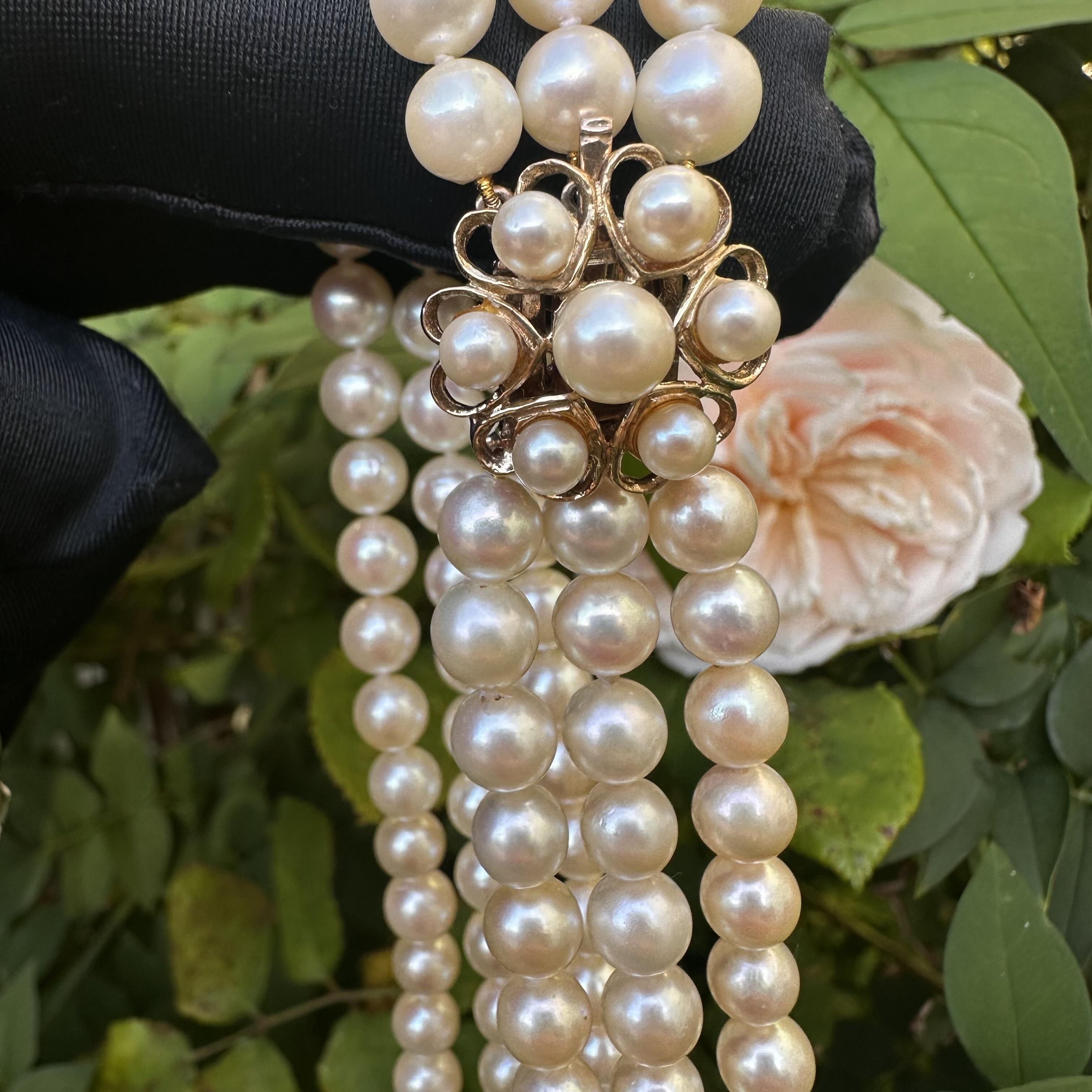 front view of Vintage Cultured Saltwater Pearl 3 Row Necklace with Gold Pearl Cluster Heart Clasp held in garden