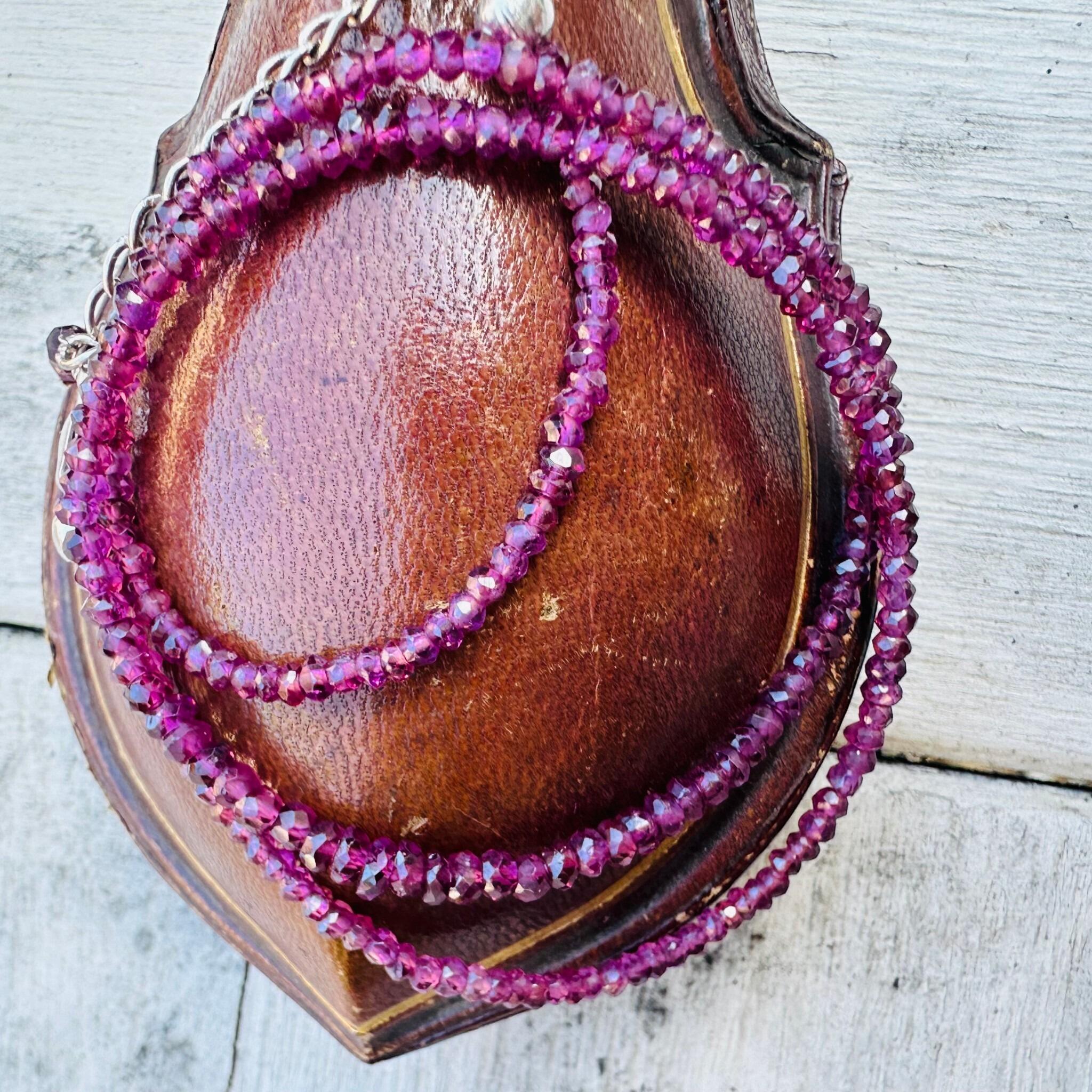 Silver & Amethyst Bead Necklace displayed on antique box with textured background