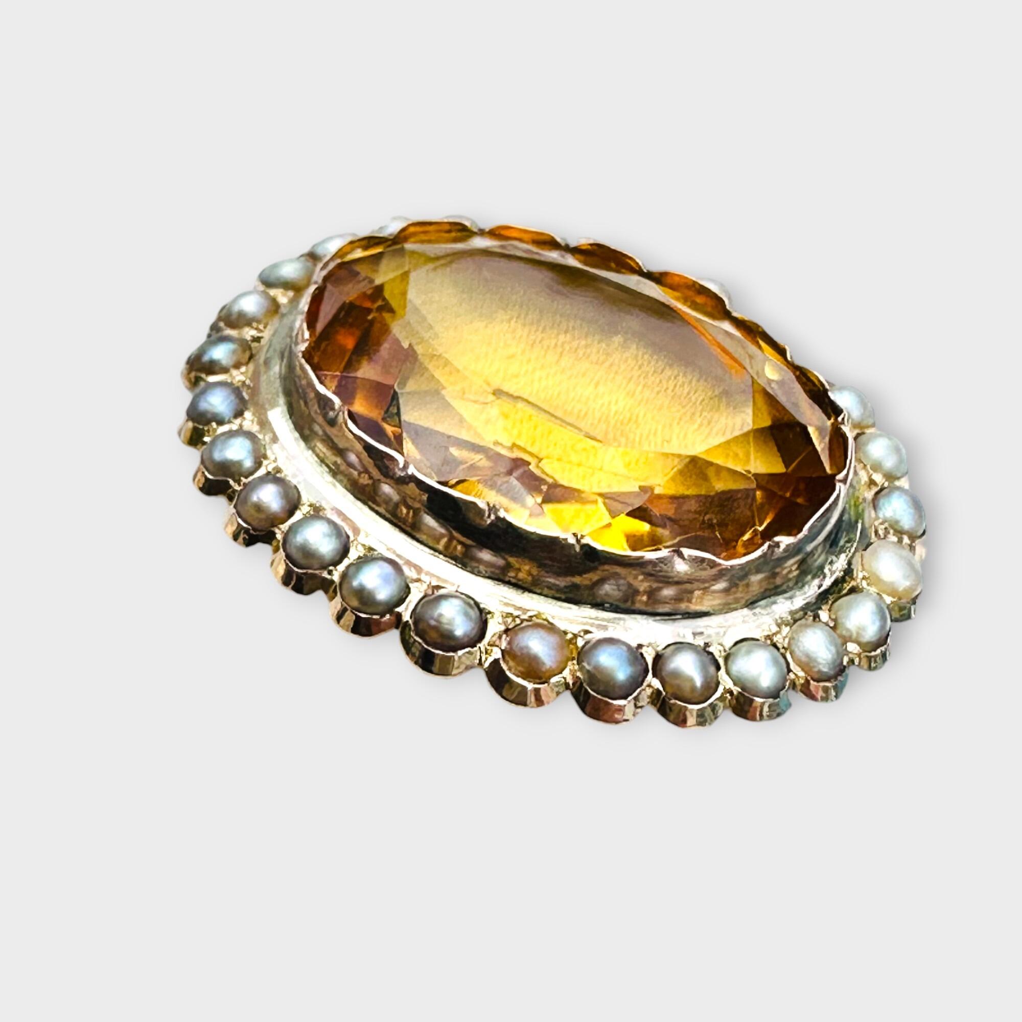 side view of Victorian citrine and pearl brooch in 9k rose gold, grey background.