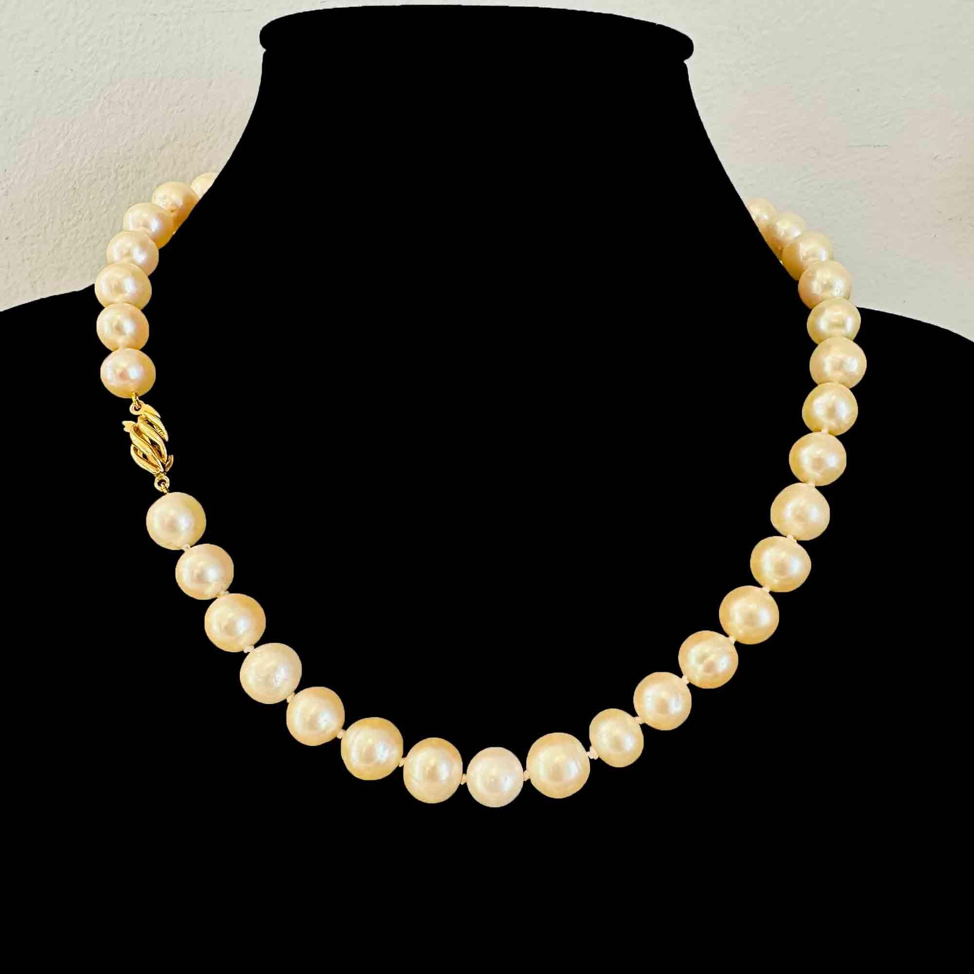 Elegant 17-inch cultured pearl necklace with oval 18K gold clasp.
