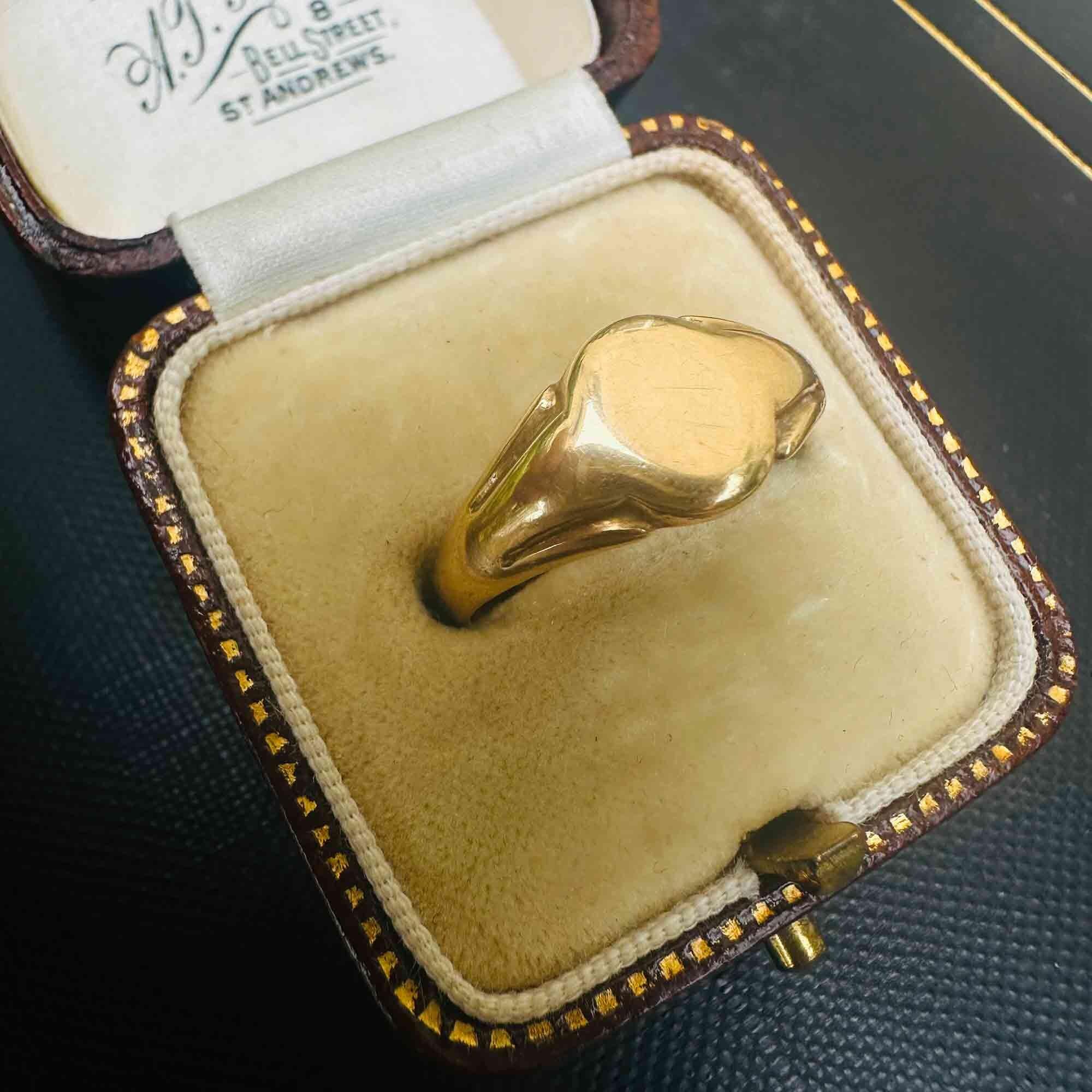 Side view of vintage 1942 18k yellow gold signet ring in antique box