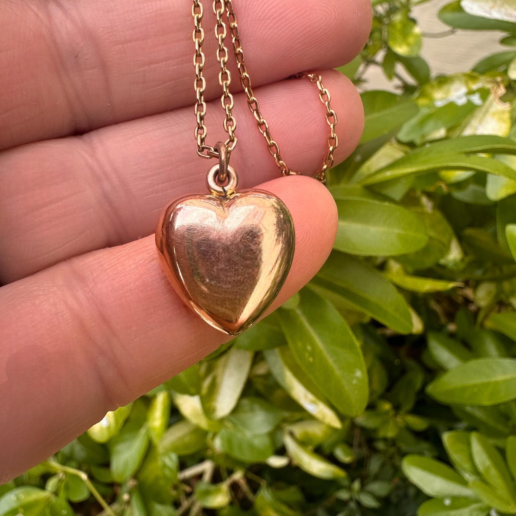 15ct Rose Gold Puffy Heart Pendant, held in hand in garden.