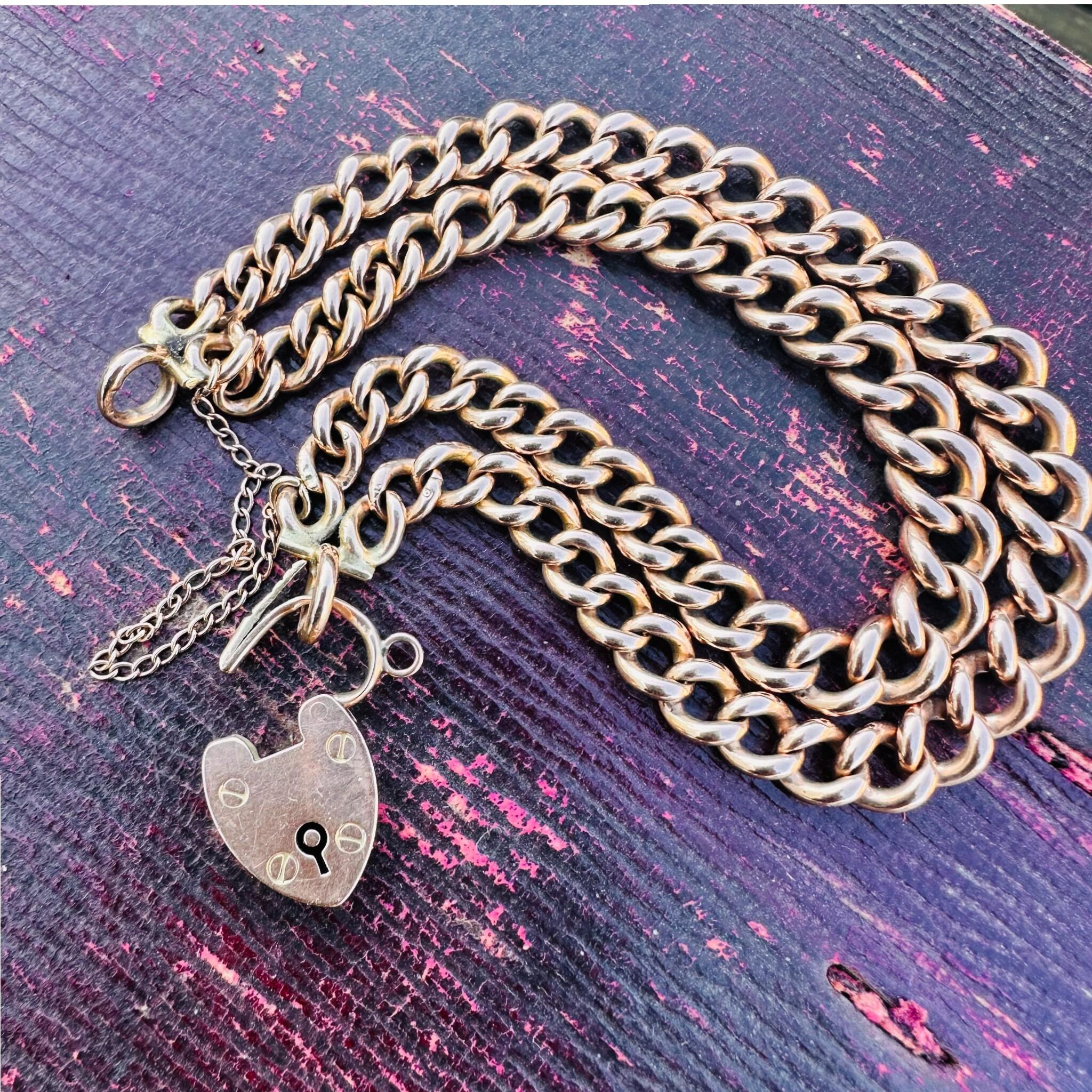 Rose Gold Double Curb Link Bracelet with Heart Padlock , displayed on antique box.