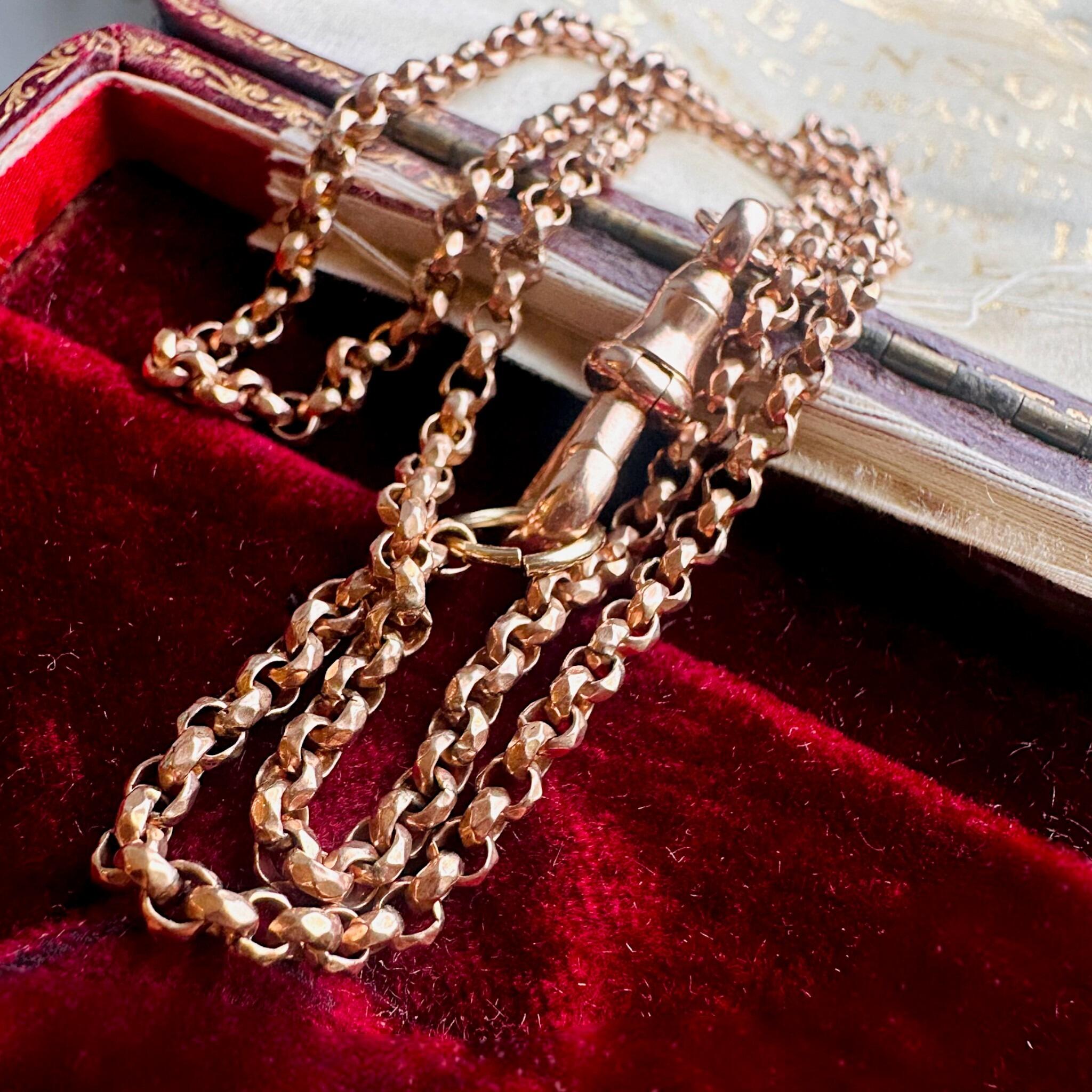 Rose Gold Faceted Belcher Chain with Dog Clip Clasp displayed on an antique box.