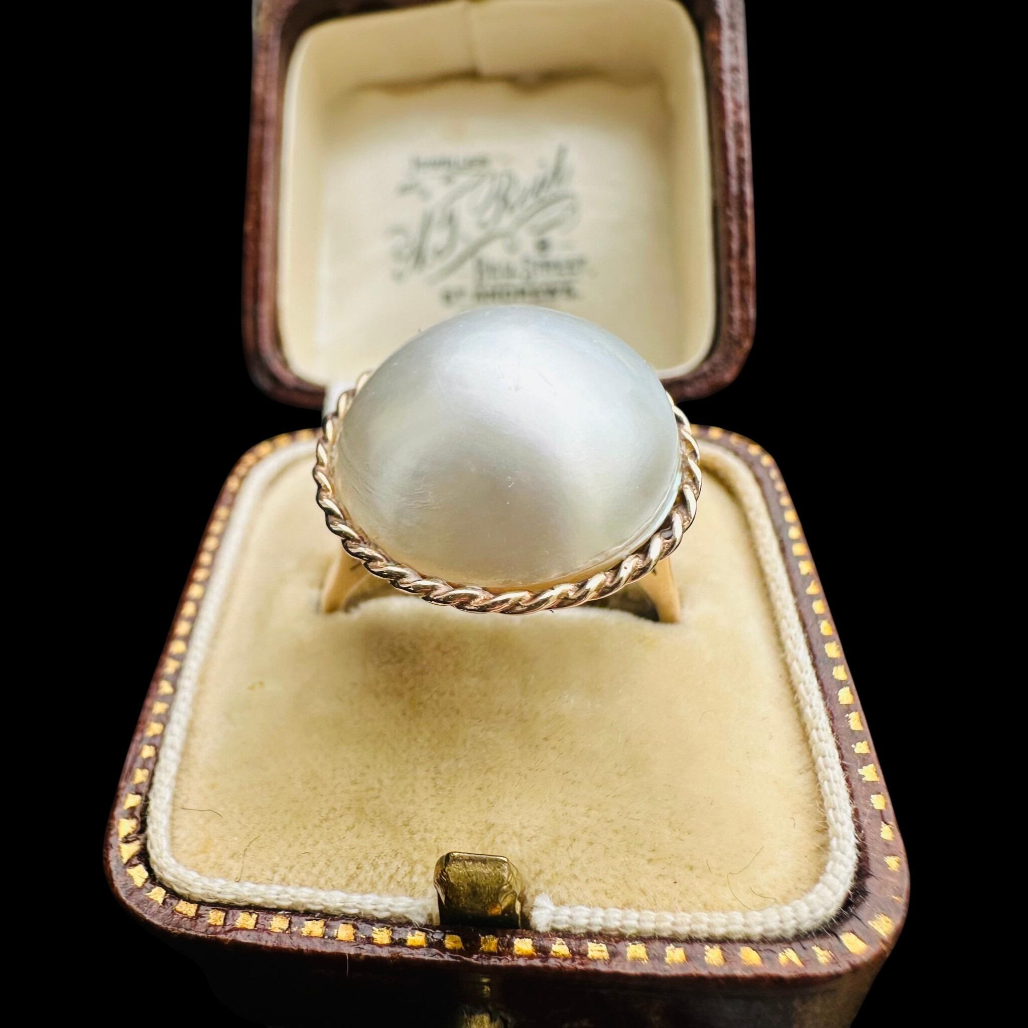 Vintage 9k Gold Mabe Pearl Cocktail Ring displayed in antique box with back background