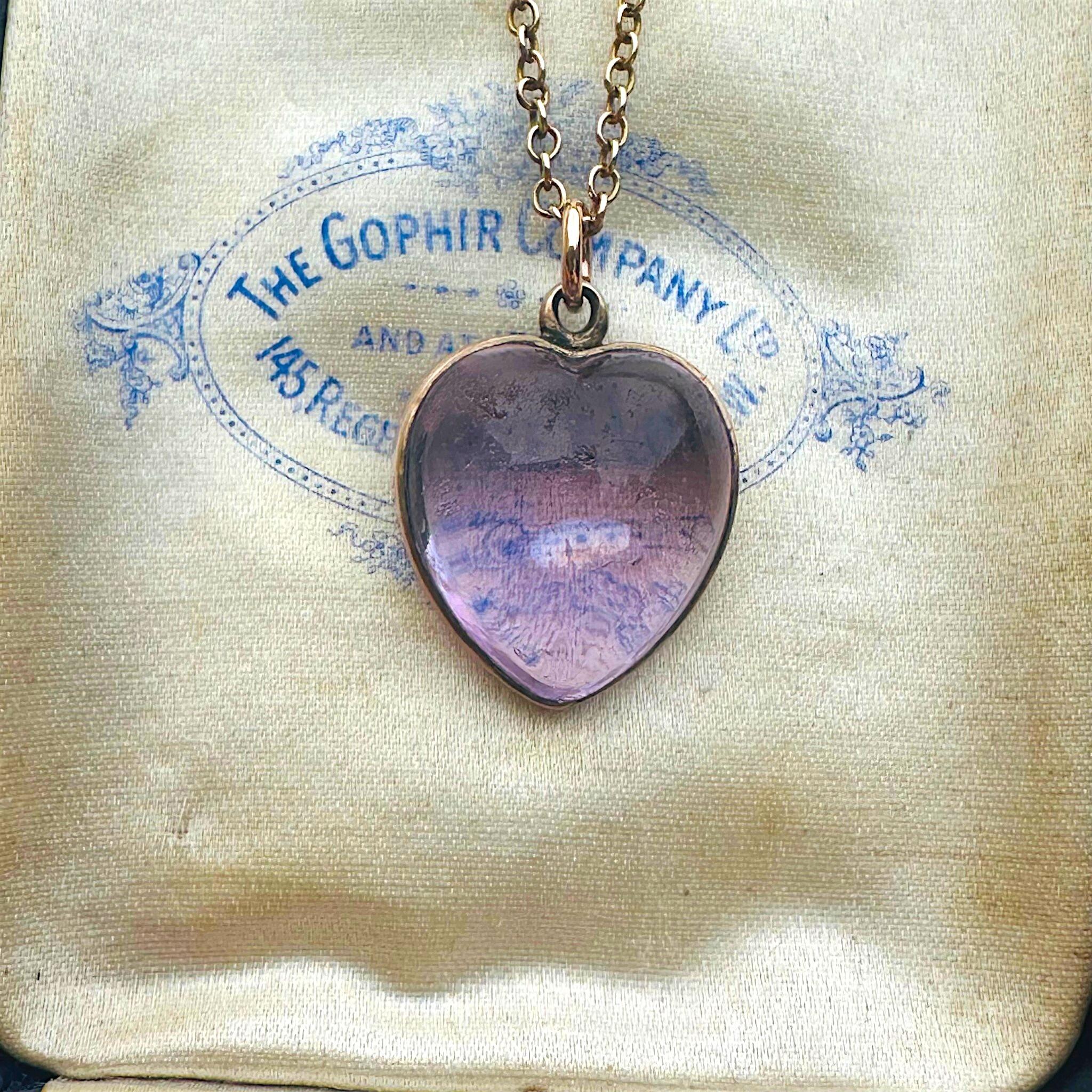 Rose de France Amethyst Heart Pendant & Gold rolo link chain displayed on antique box