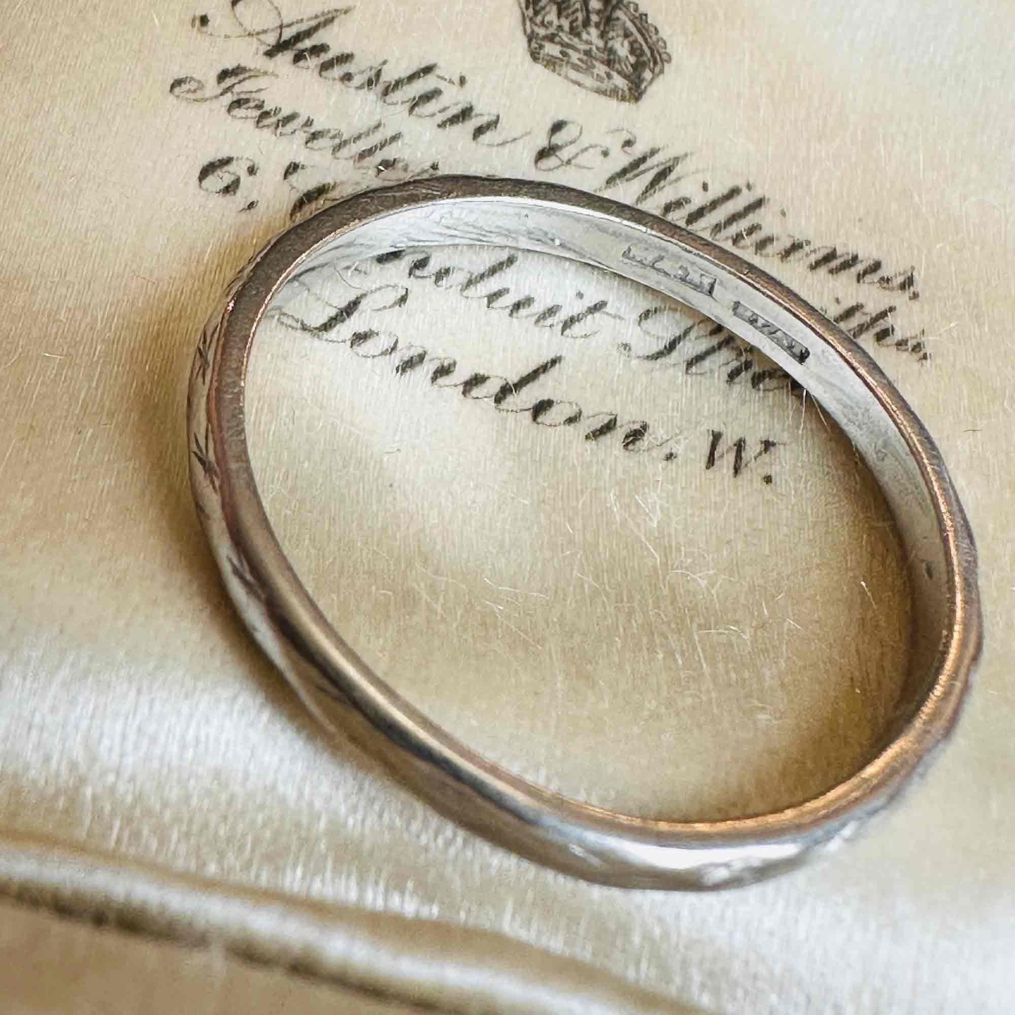 side profile of Art Deco Hand Engraved Platinum Wedding Band displayed on antique box