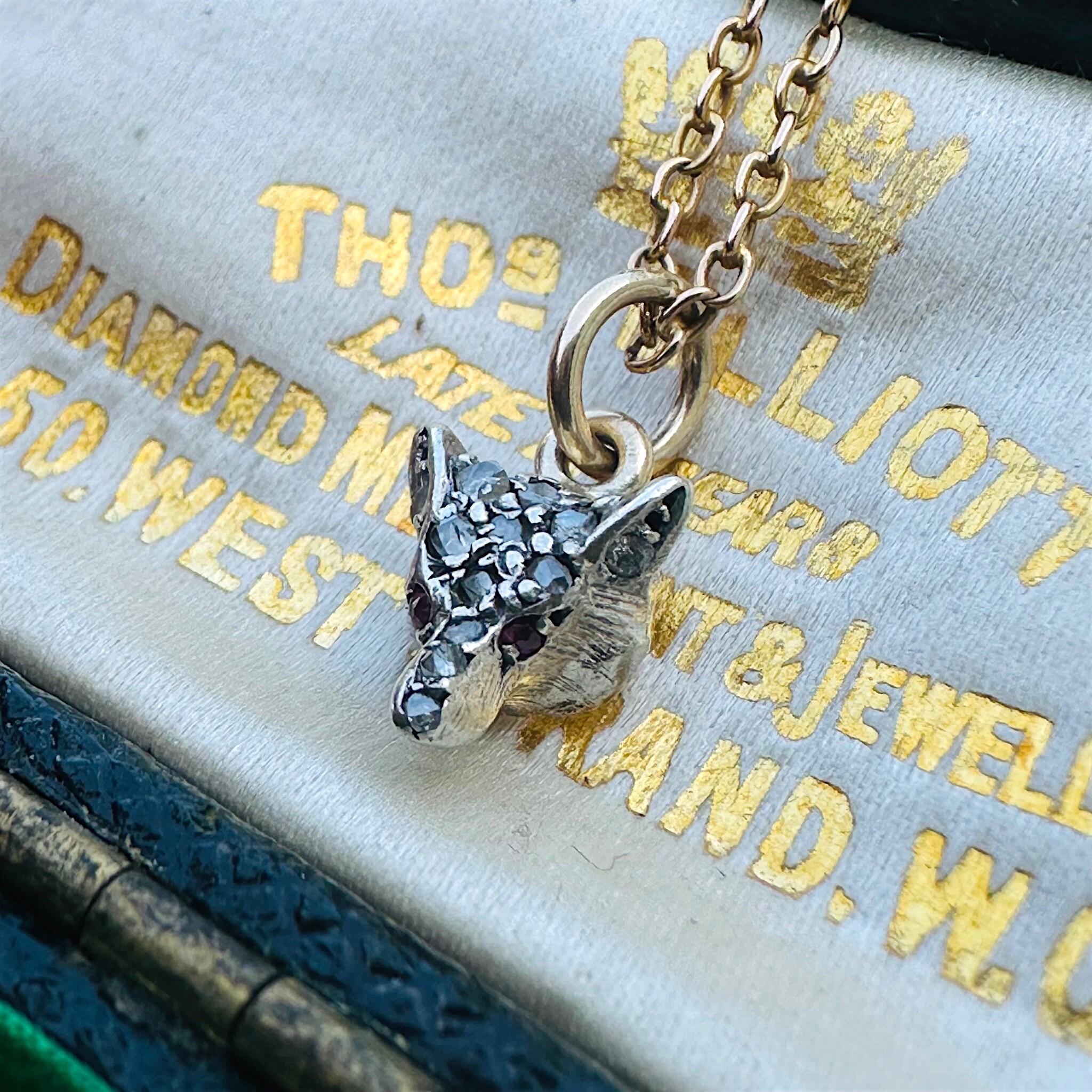 Victorian Diamond & Ruby Eyes Fox Pendant displayed laying on antique box