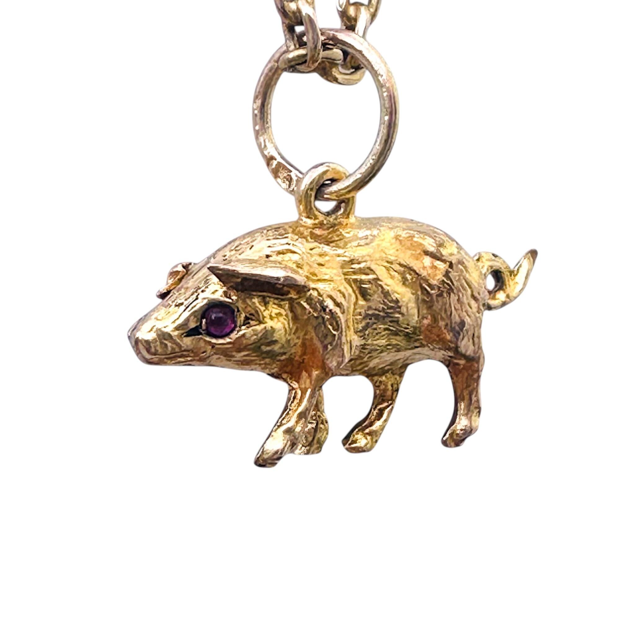 side profile of Gold & Ruby Eyed Pig Charm, white background.