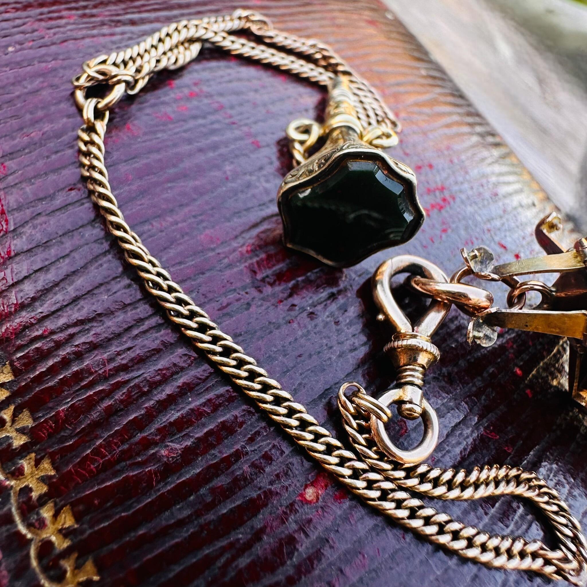 side profile of Rare Antique Rose Gold, Opening Hexagonal Cross Masonic Pendant & Bloodstone Watch Key Fob laying on red antique box