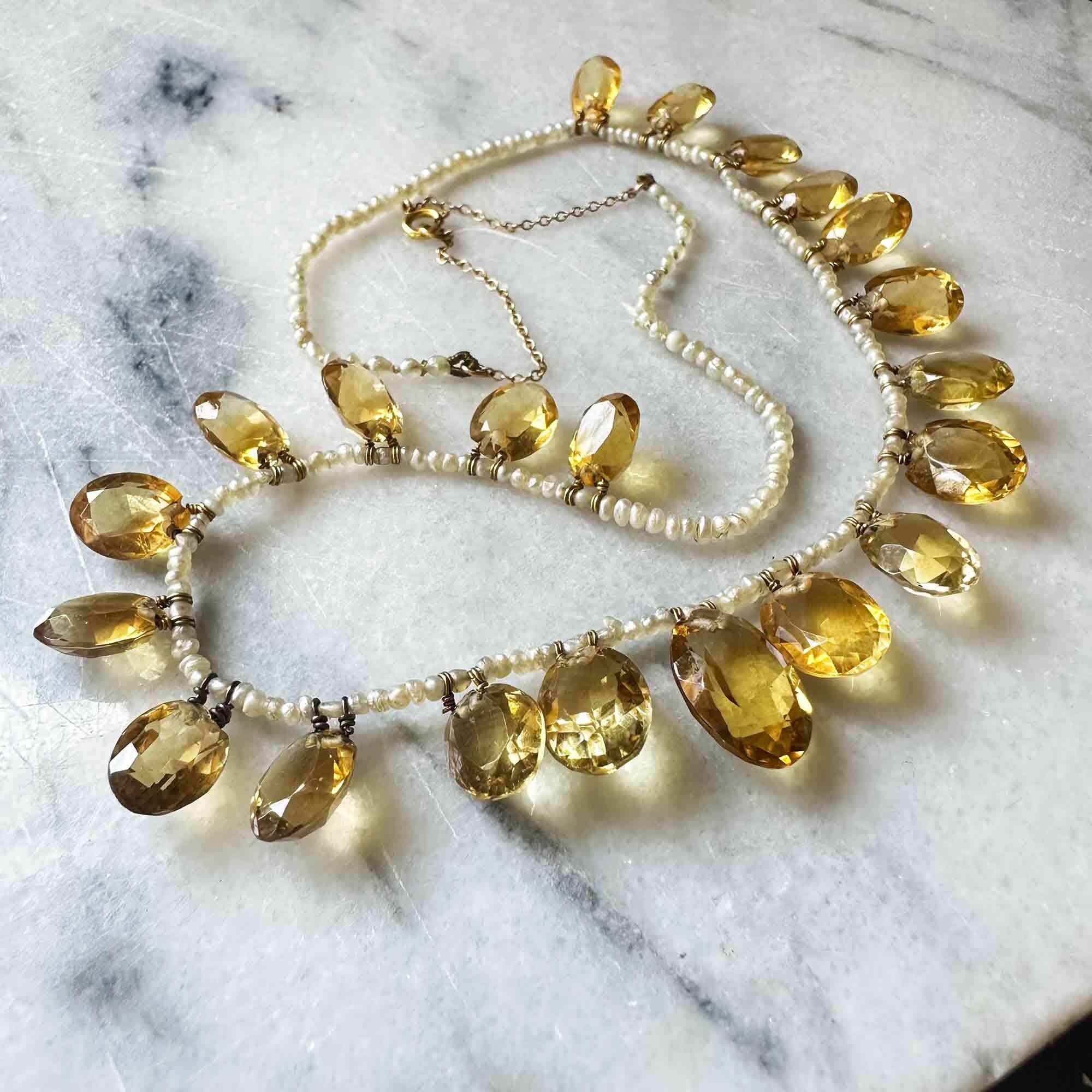 Necklace laid flat showing graduated citrine sizes and pearl spacing