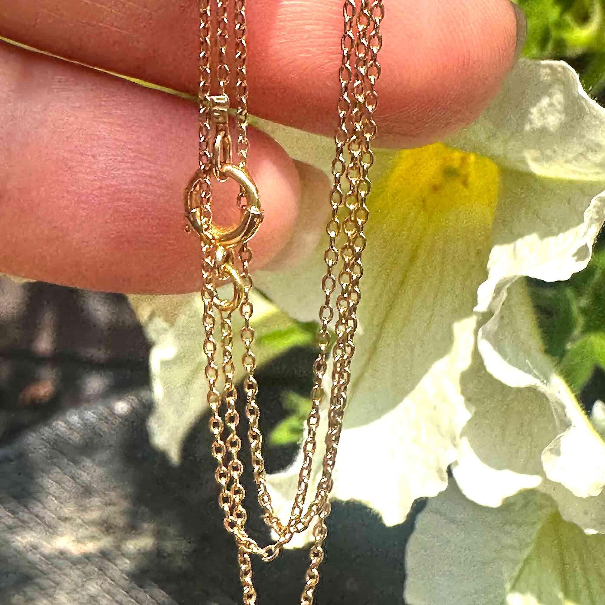 Close-up of rare antique Edwardian 15ct gold rolo link chain on white background.