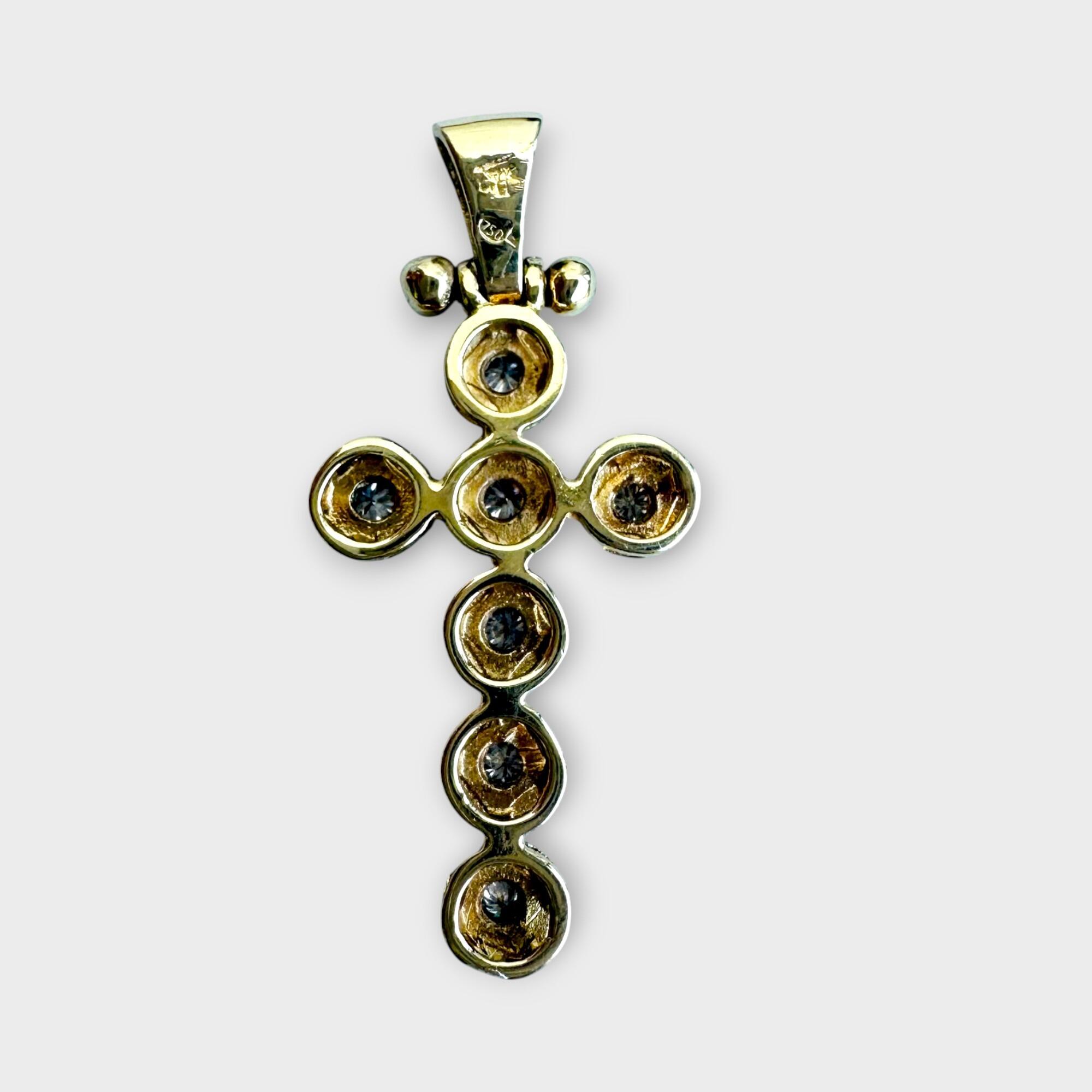 back view of 18ct yellow gold and diamond cross pendant on grey background.