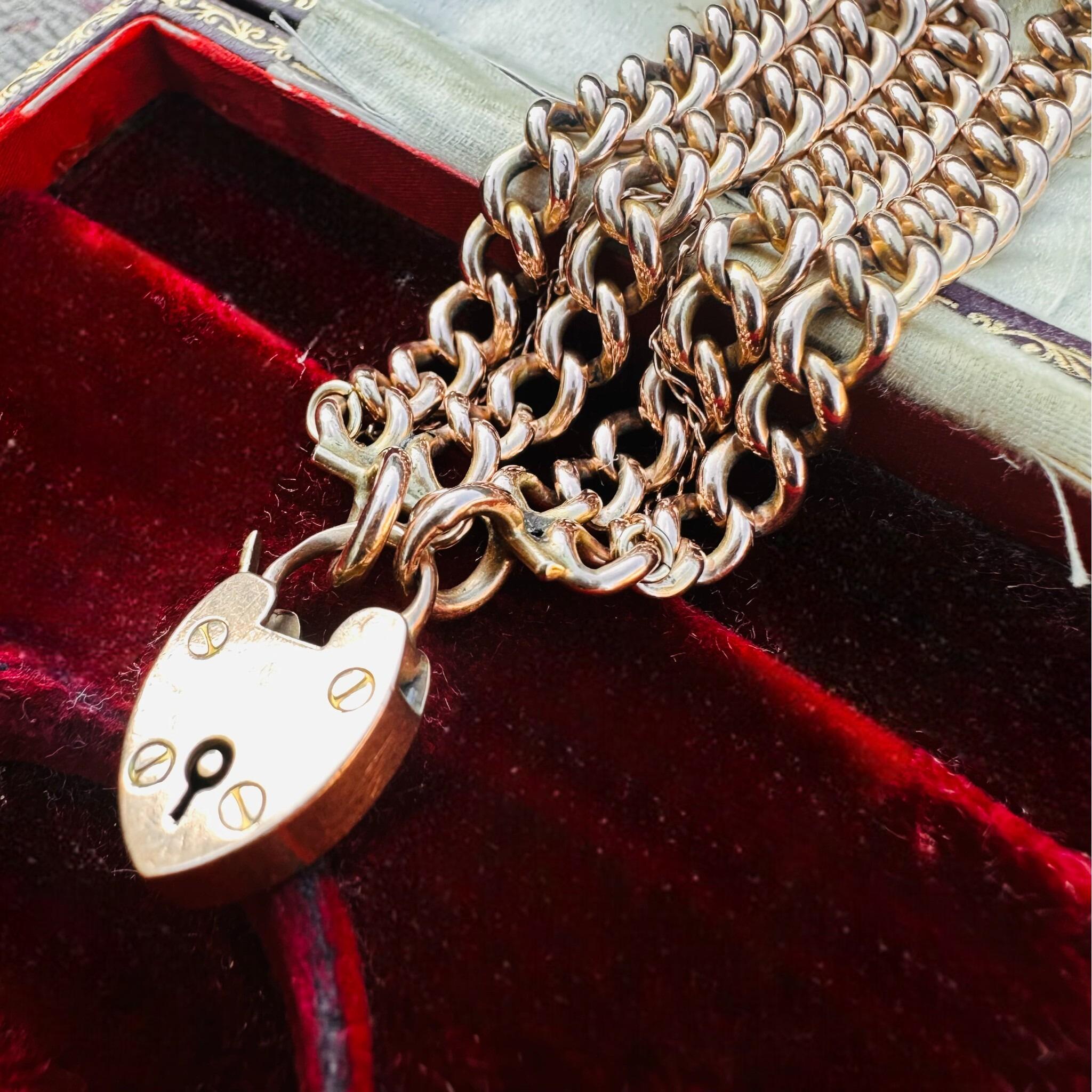 Rose Gold Double Curb Link Bracelet with Heart Padlock , displayed on antique box.