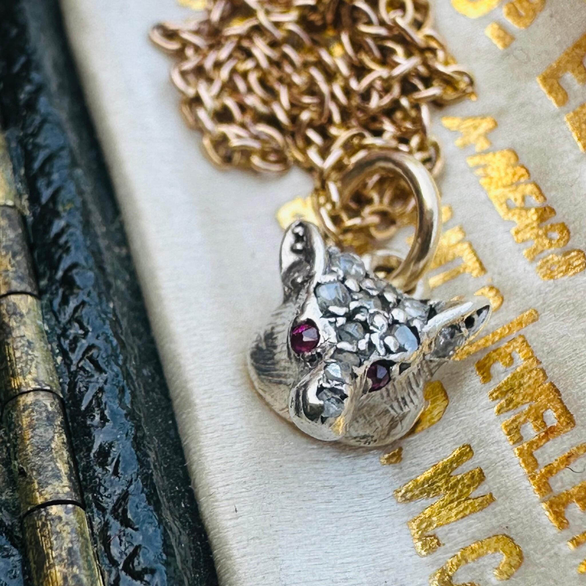 Victorian Diamond & Ruby Eyes Fox Pendant displayed laying on antique box