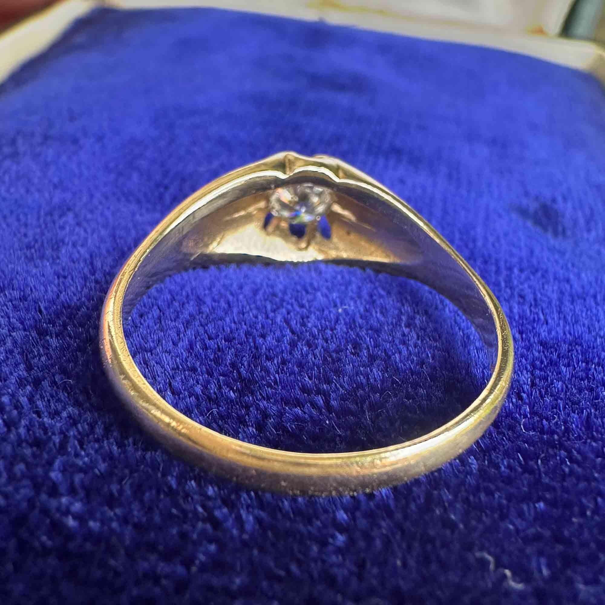 reverse view of gents gold diamond solitaire gypsy ring on blue velvet pad
