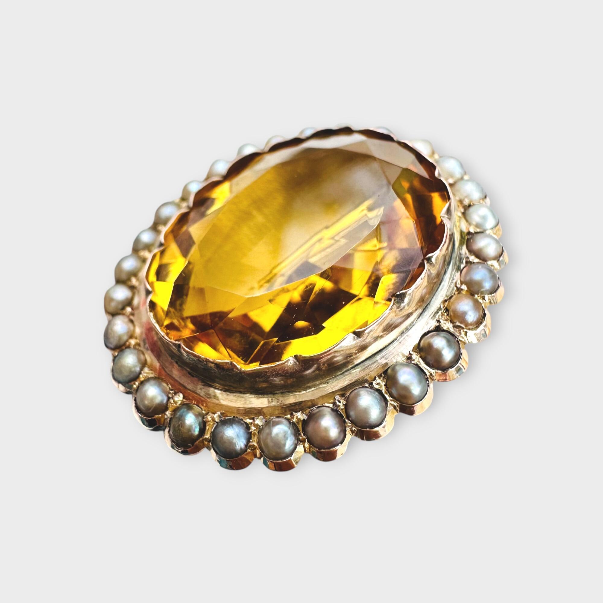 side view of Victorian citrine and pearl brooch in 9k rose gold, grey background.