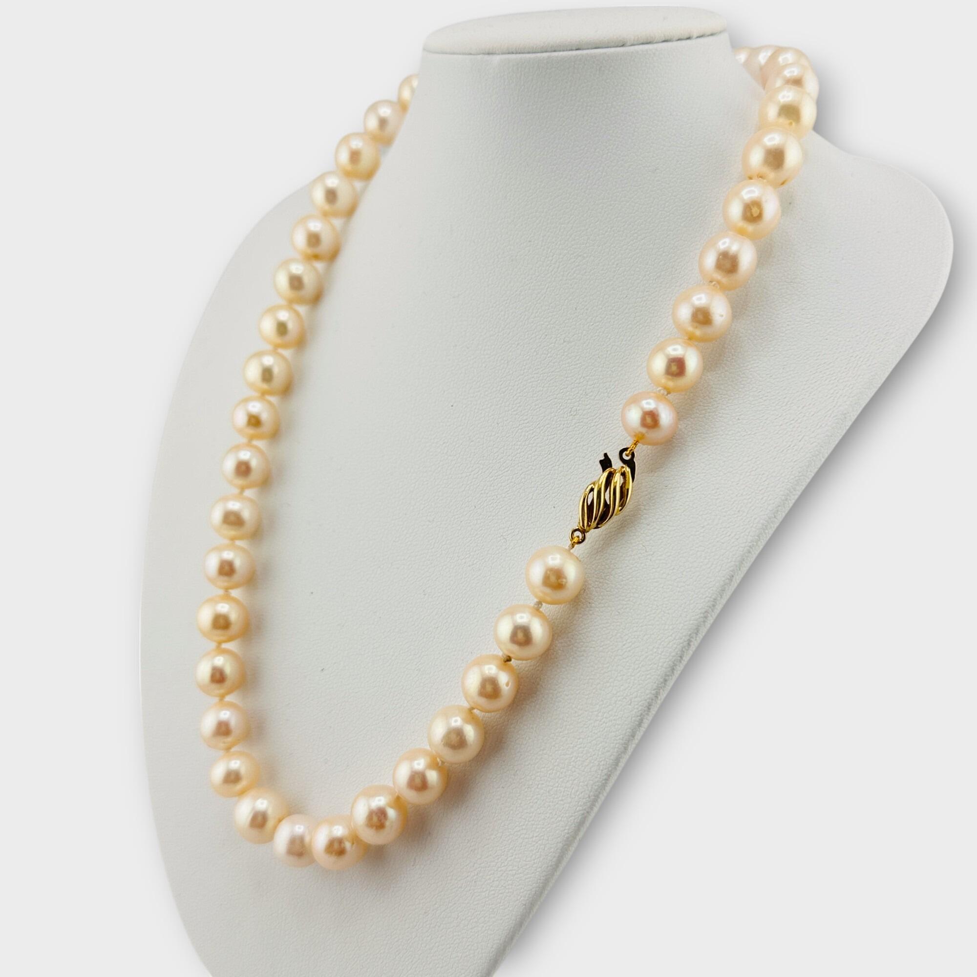 side view, Elegant 17-inch cultured pearl necklace with oval 18K gold clasp, displayed on white breast.