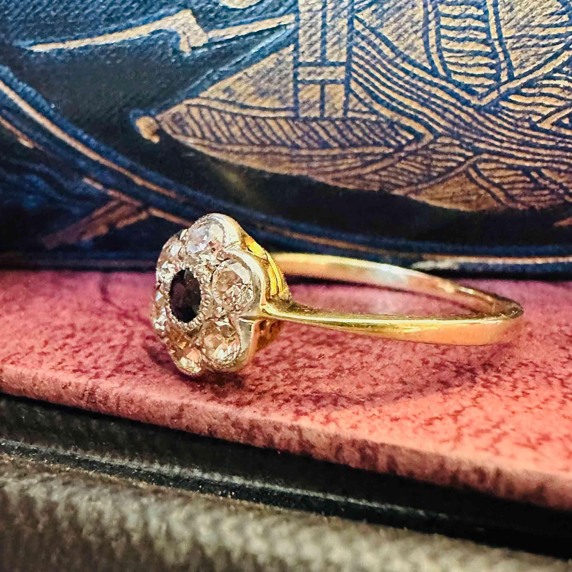 Side view, Art Deco 18k gold Sapphire and diamond cluster daisy ring on antique boxes.