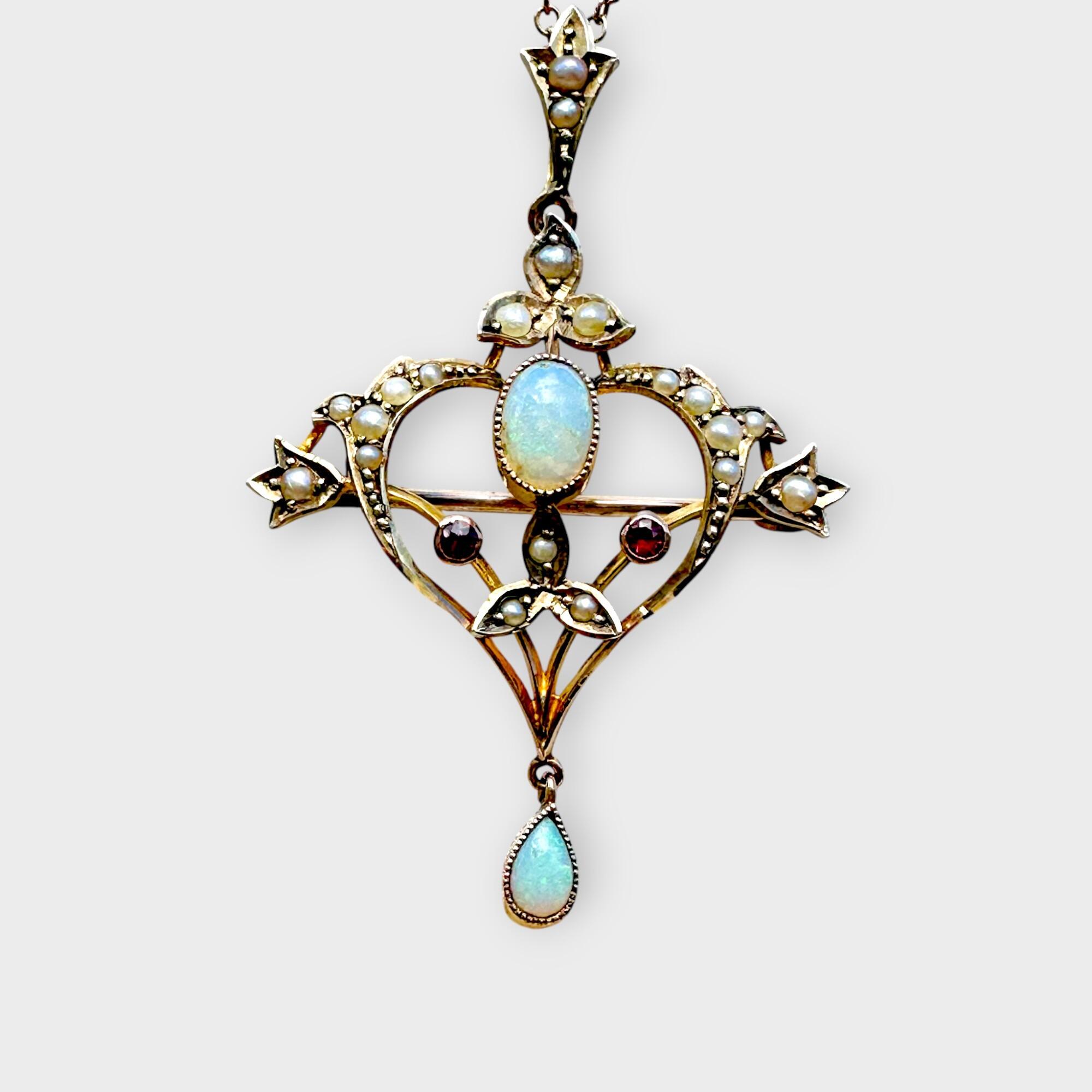 Art Nouveau 9k gold pendant brooch with opals, rubies, and pearls with grey background.