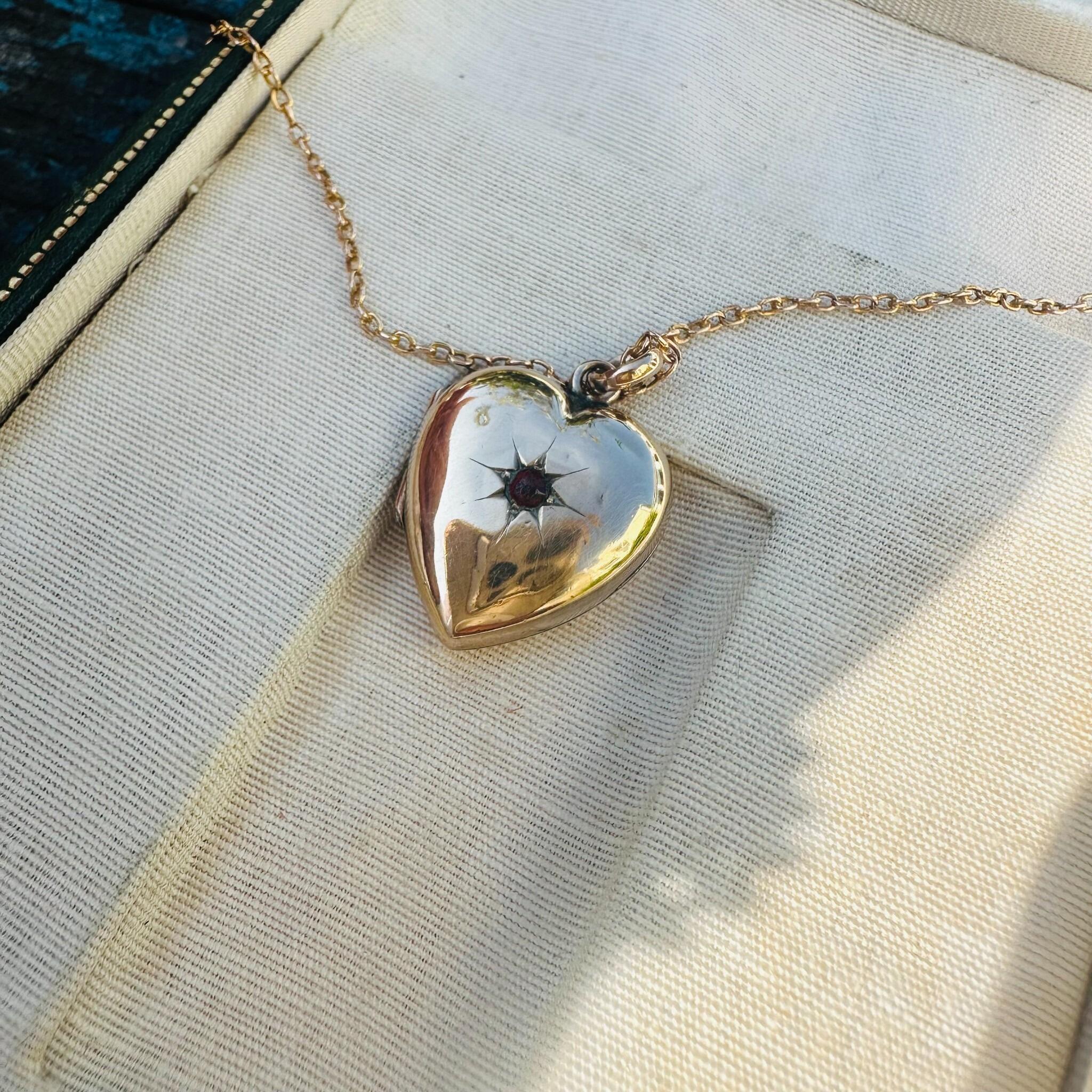Victorian Gold Heart Locket Pendant with Garnet Star-Set Detail, displayed in antique box.