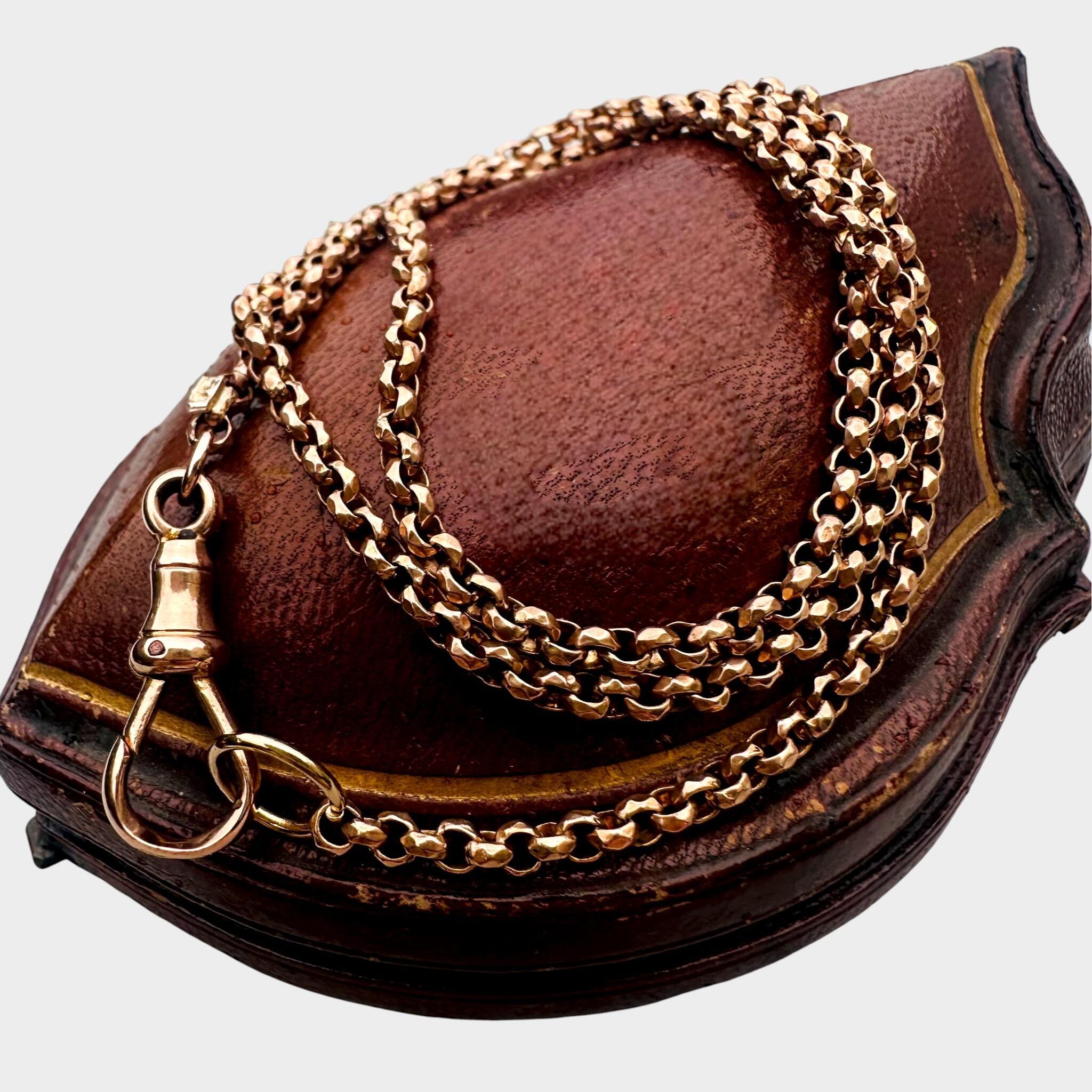 Rose Gold Faceted Belcher Chain with Dog Clip Clasp displayed on an antique box.