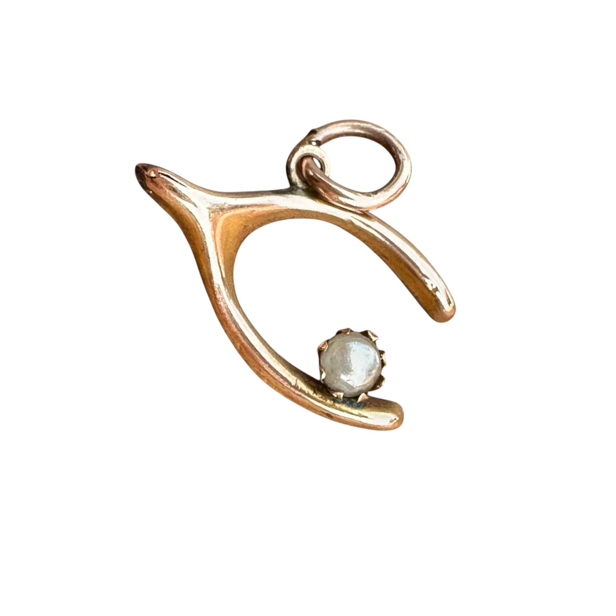 Pretty Victorian wishbone and pearl charm charm made of 9ct (375) rosegold, featuring a delicate wishbone design adorned with a single white pearl on white background.