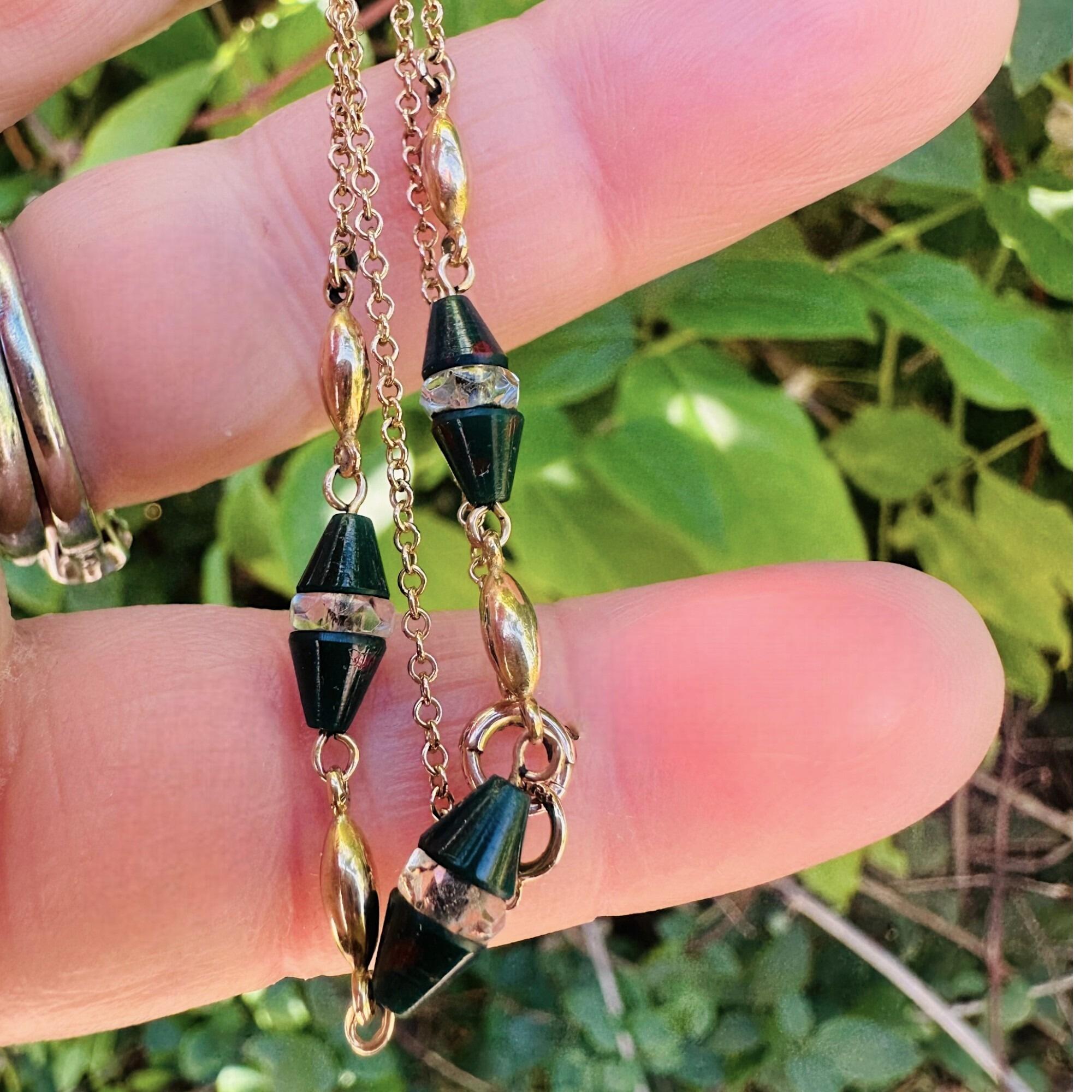 Antique Art Deco 9k Gold Bloodstone & Rock Crystal Bead Chain held in hand, in garden