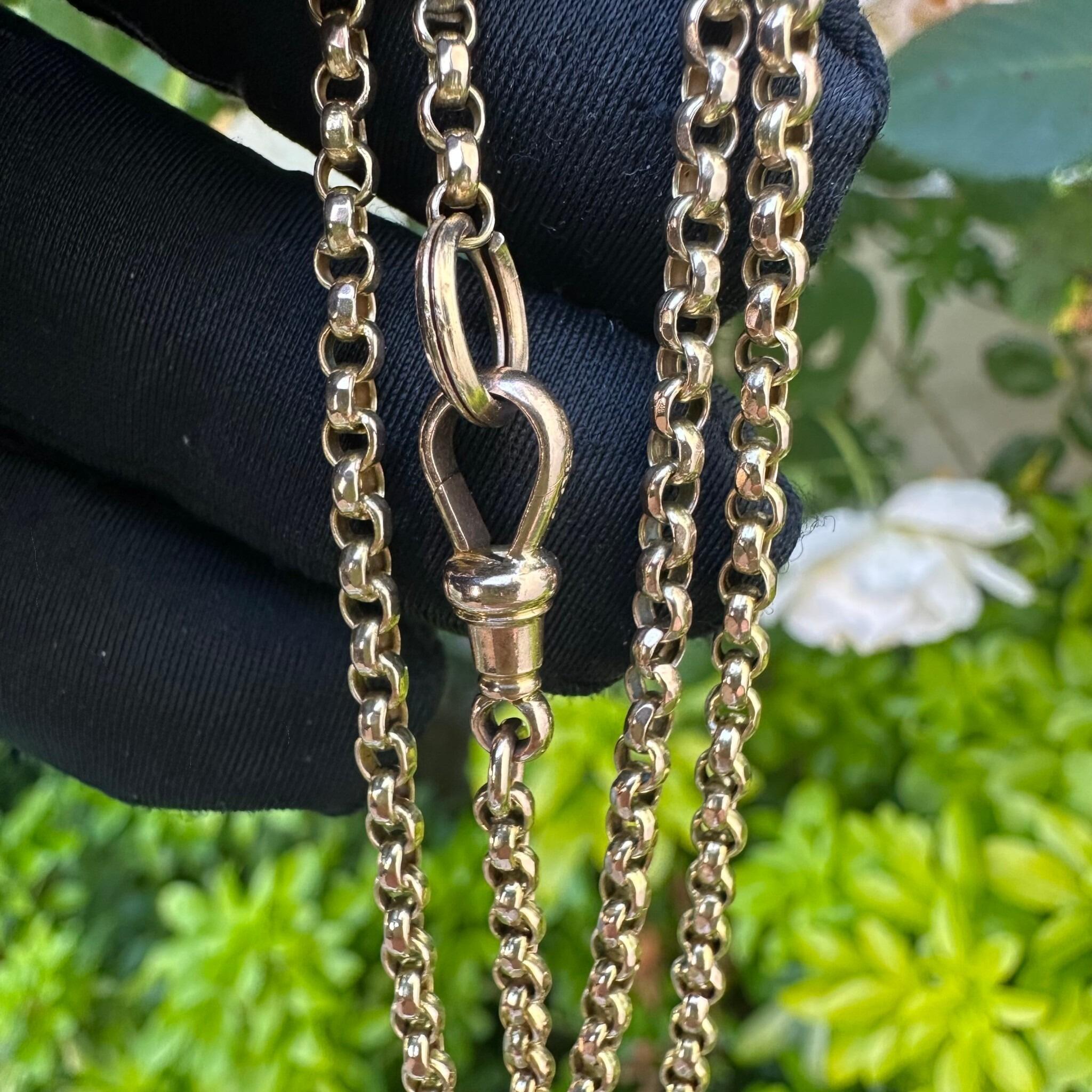 Antique Victorian 9ct Rose Gold Belcher Chain With Dog Clip & Split Ring clasp held in gloved hand in garden