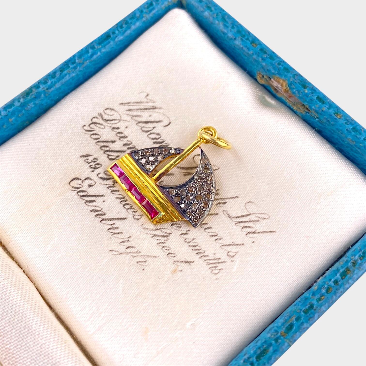 Vintage Diamond & Red Spinel Yacht Pendant Charm displayed on antique box
