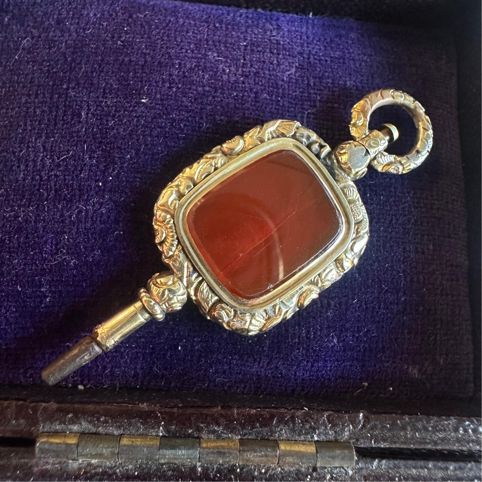 Antique Georgian Carnelian Watch Key Pendant displayed on purple velvet box