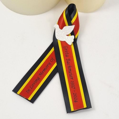 German funeral ribbon. Red yellow and black with white dove