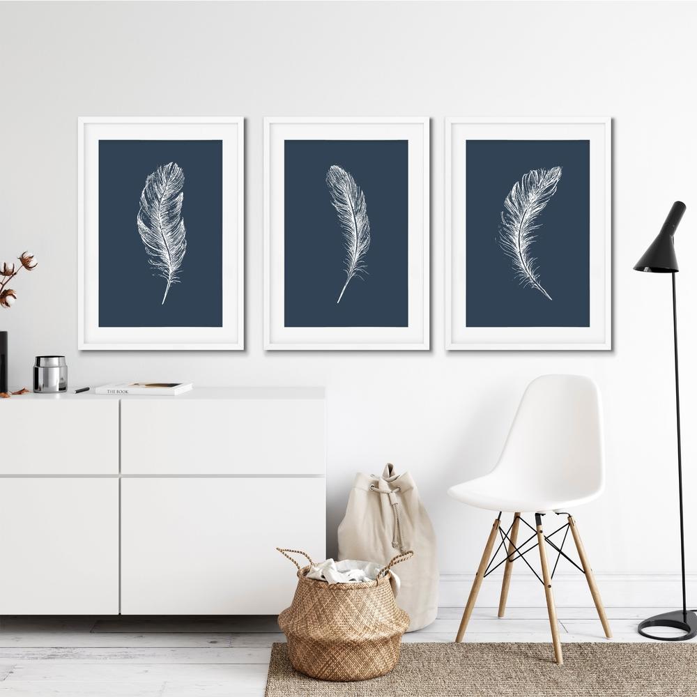Set Of 3, navy feather A4 wall prints, on a white wall in a white interior setting.