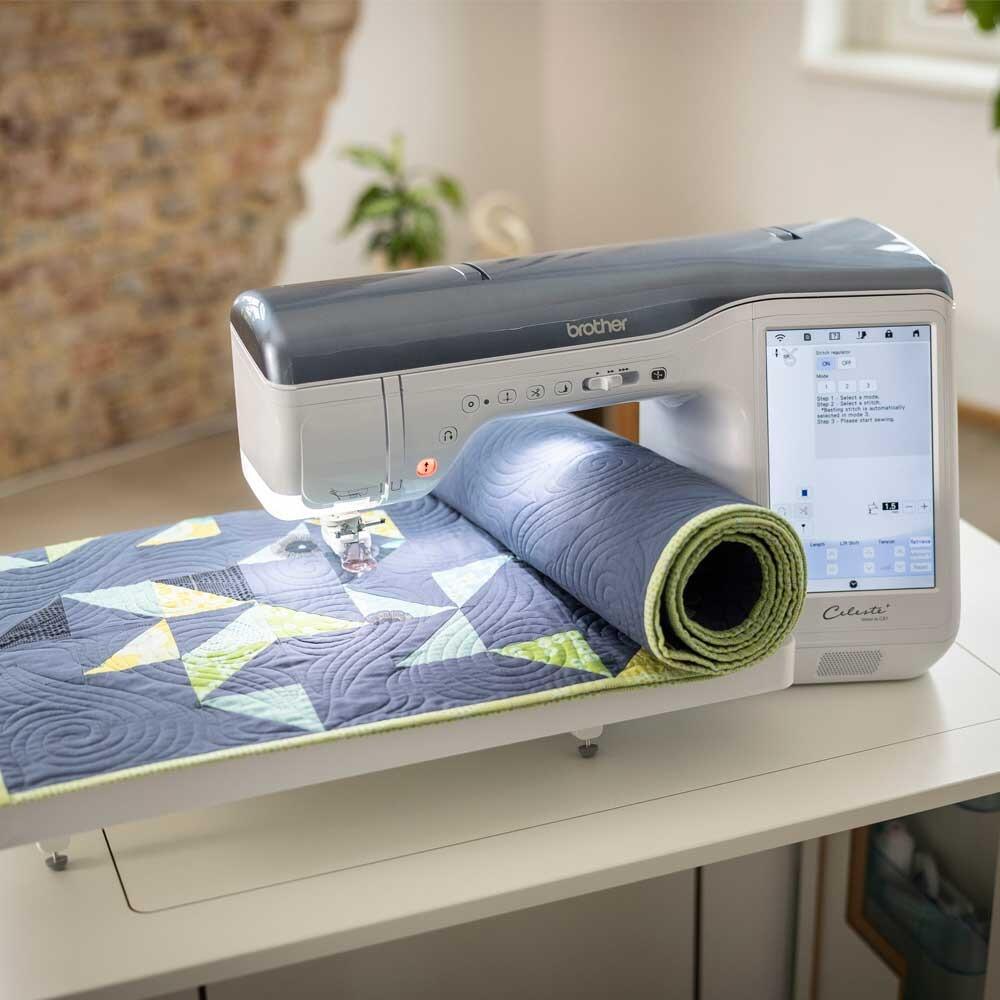 Brother celeste CX1 sewing machine with a rolled up quilt being sewn