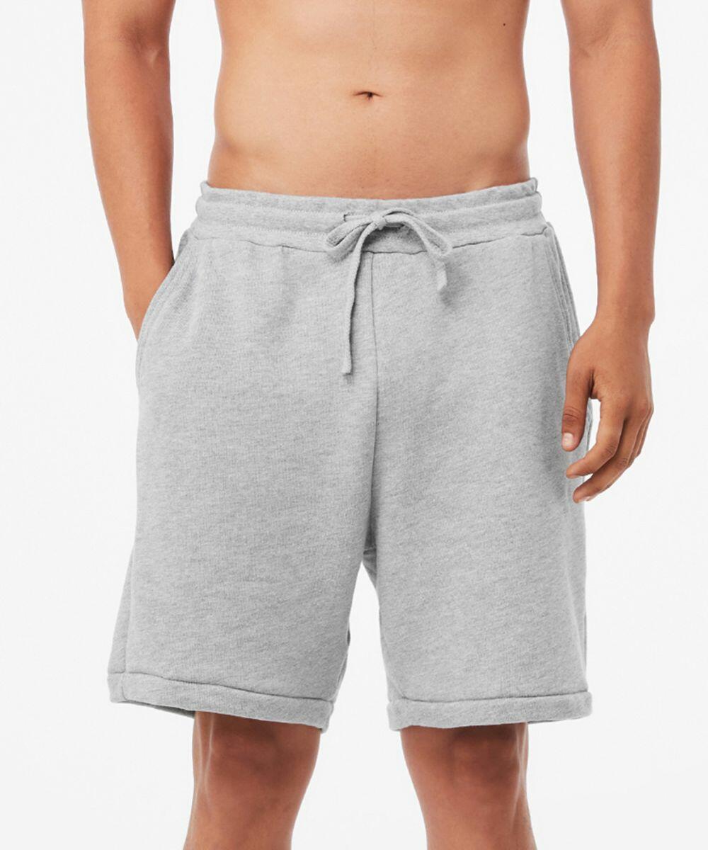 A person is wearing Bella Canvas BE135 gray, knee-length sweat shorts with an adjustable drawstring at the waist. The shorts have a relaxed fit and two side pockets. The person is shown from mid-torso to just above the knees, against a plain white background.