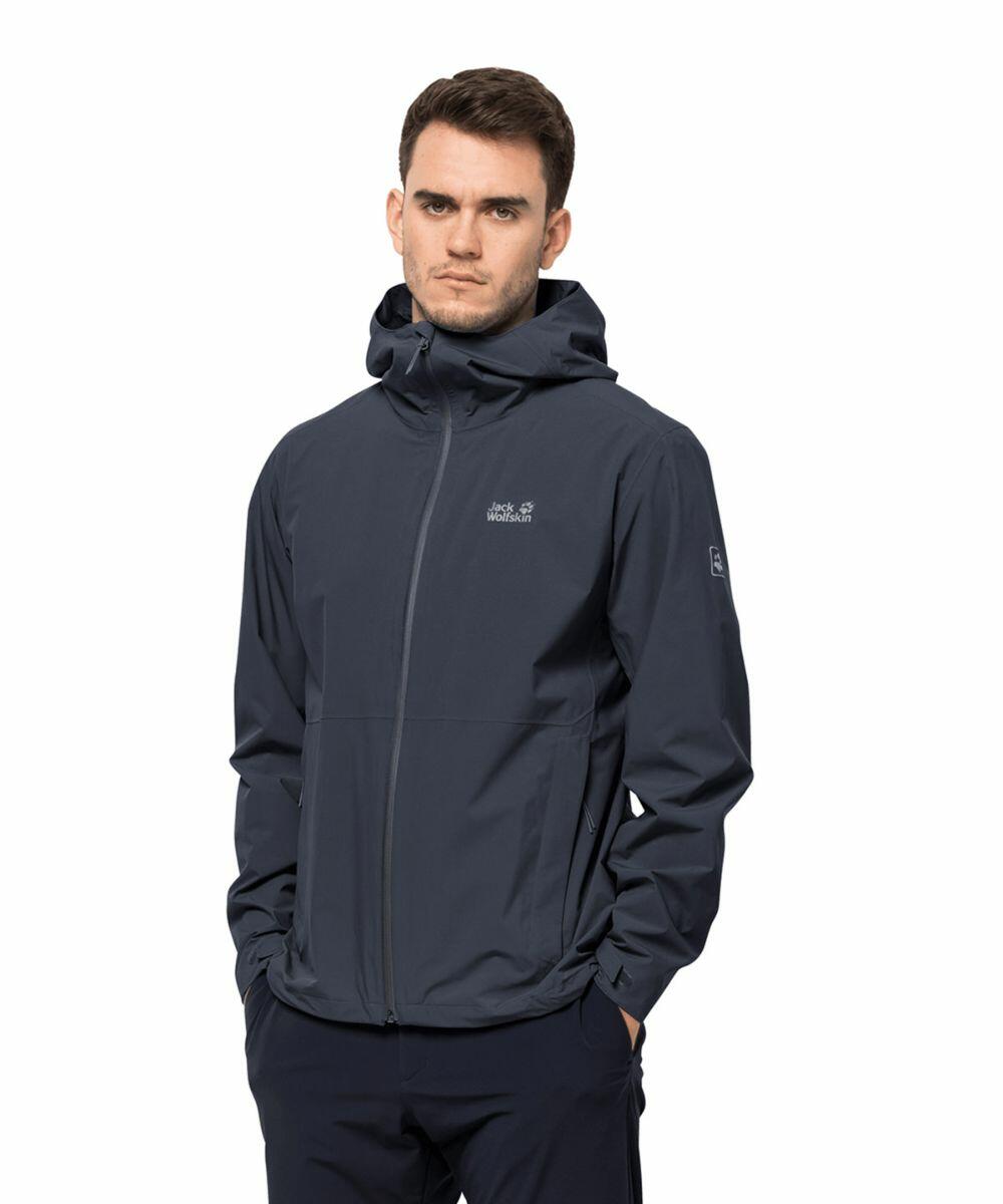 A man is wearing a dark gray JW001 zip-up jacket with a hood by Jack Wolfskin. His hands are in the jacket pockets and he is standing against a plain white background.