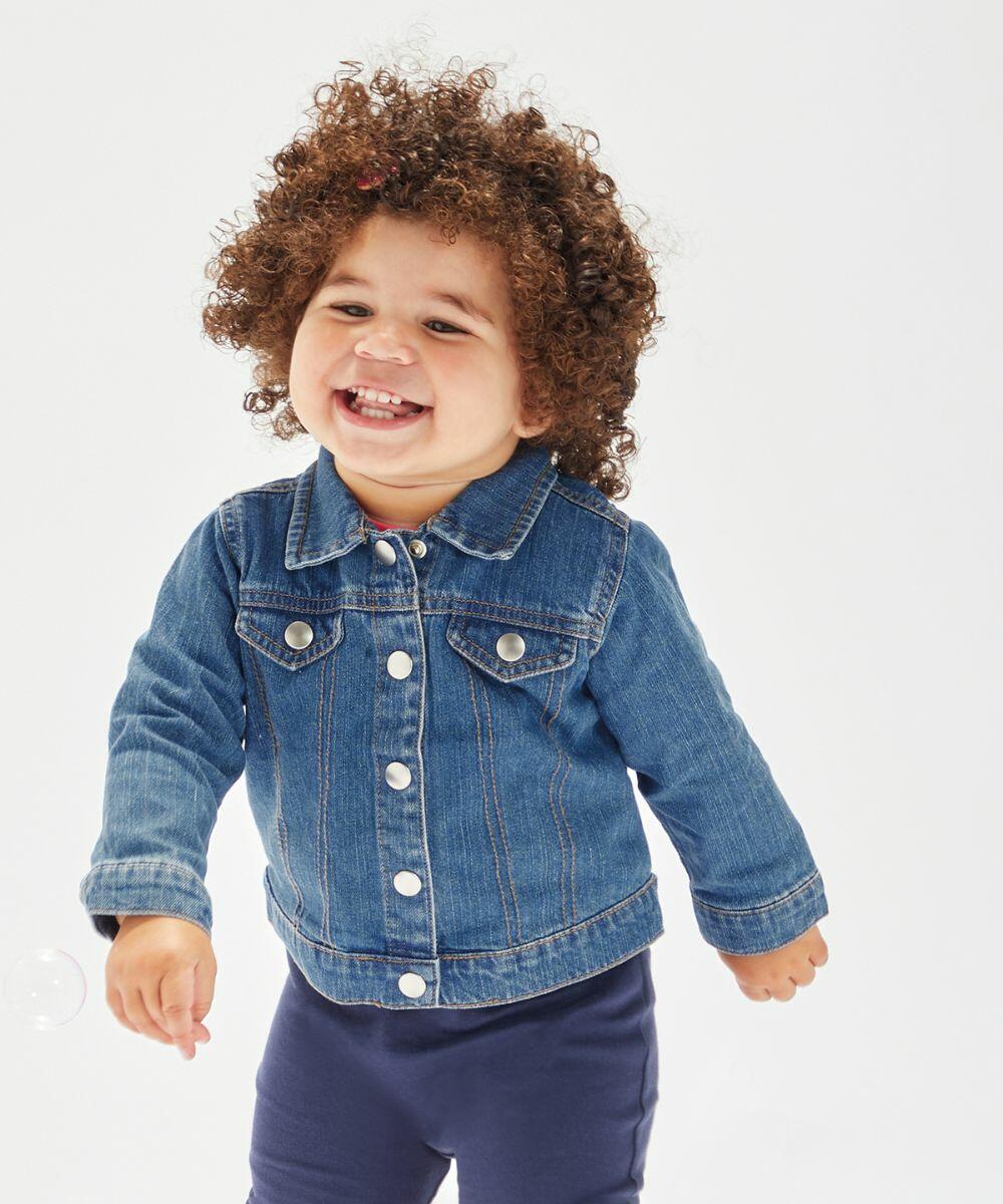 A toddler with curly hair smiles and looks to the side while wearing a Babybugz BZ053 denim jacket.