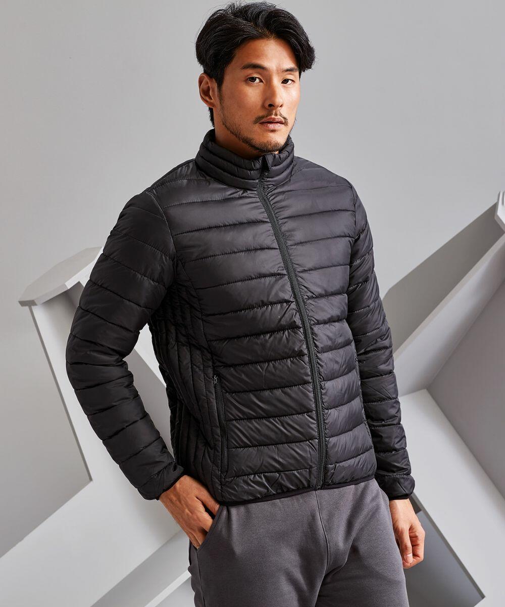 A man stands against a grey background wearing a black TS041 puffer jacket by 2786 and grey pants, looking directly at the camera.