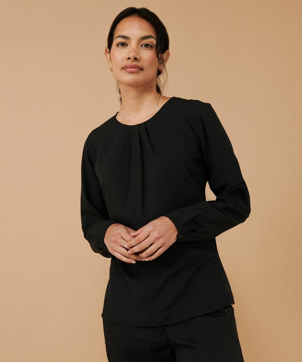A person with dark hair, wearing a long-sleeve black Henbury HB598 blouse, stands against a beige background.