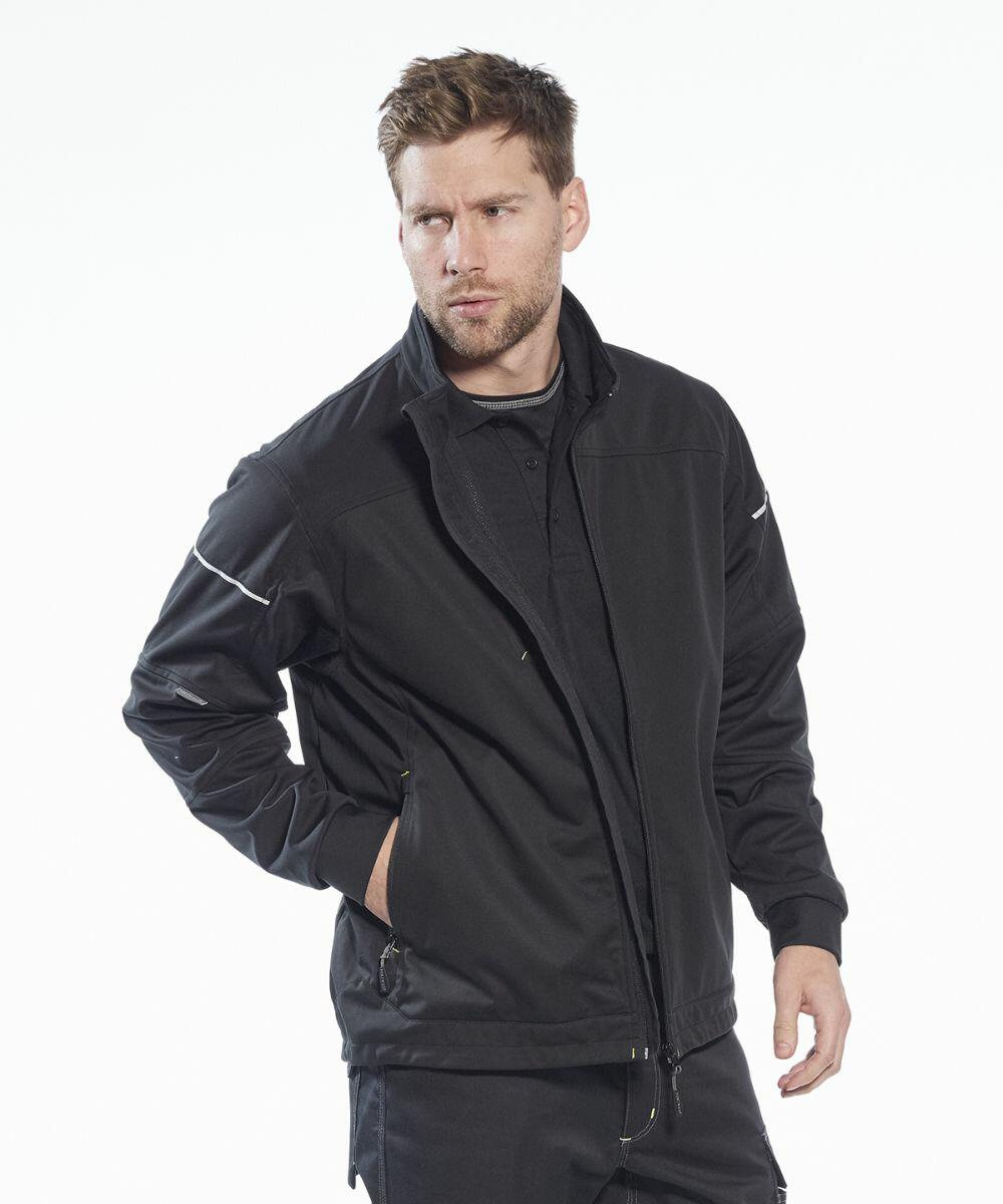 A man with light brown hair wearing a black PW365 jacket by Portwest stands with his right hand in his pocket against a white background.