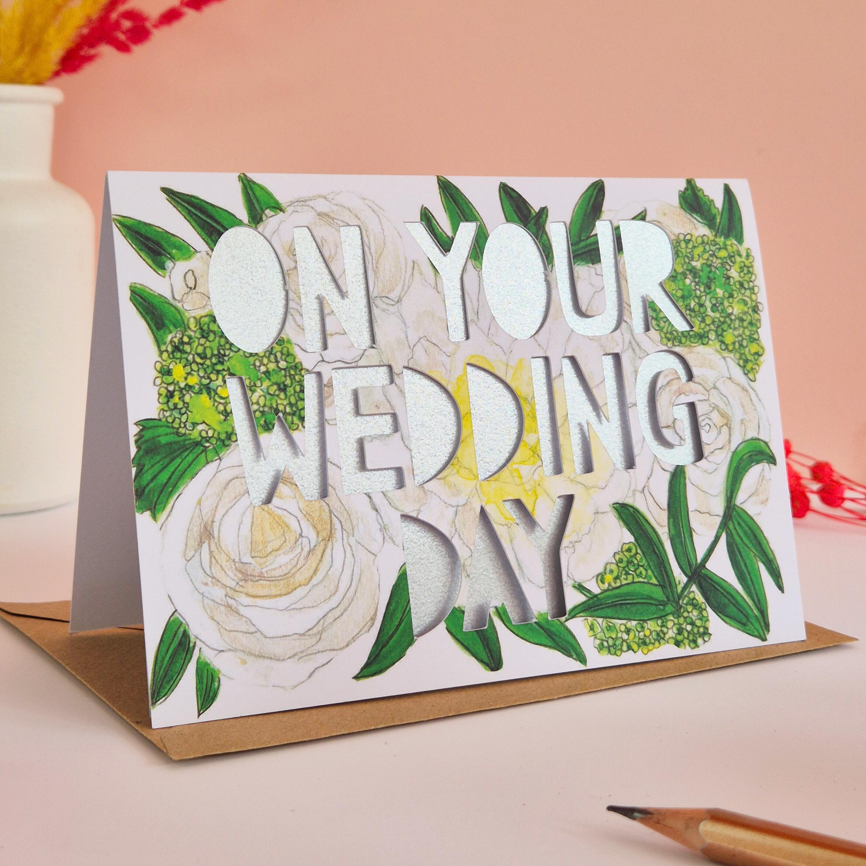 White and green floral illustration card with On Your Wedding Day die cut text and shimmering silver backing paper liner