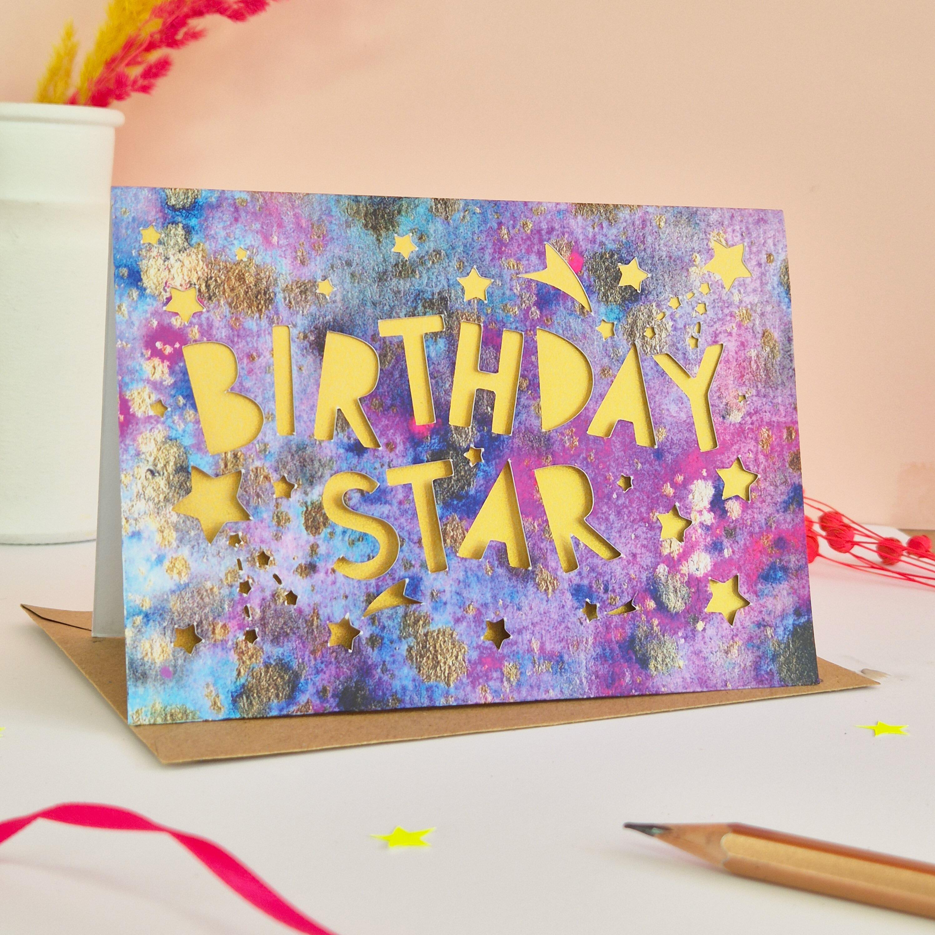 Celestial themed birthday card with die cut Birthday Star text and stars with shimmering gold paper liner