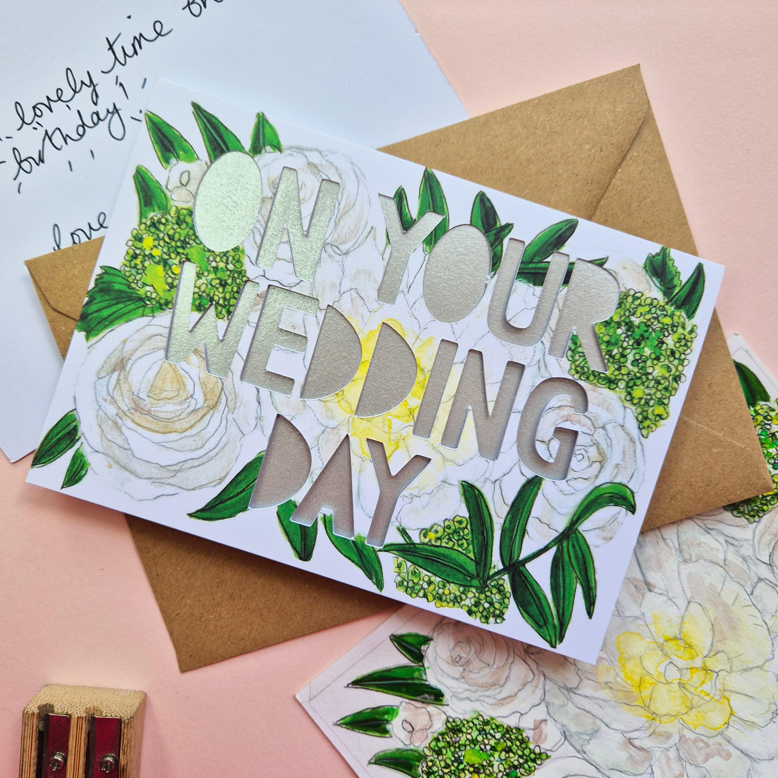 White and green floral illustration card with On Your Wedding Day die cut text and shimmering silver backing paper liner