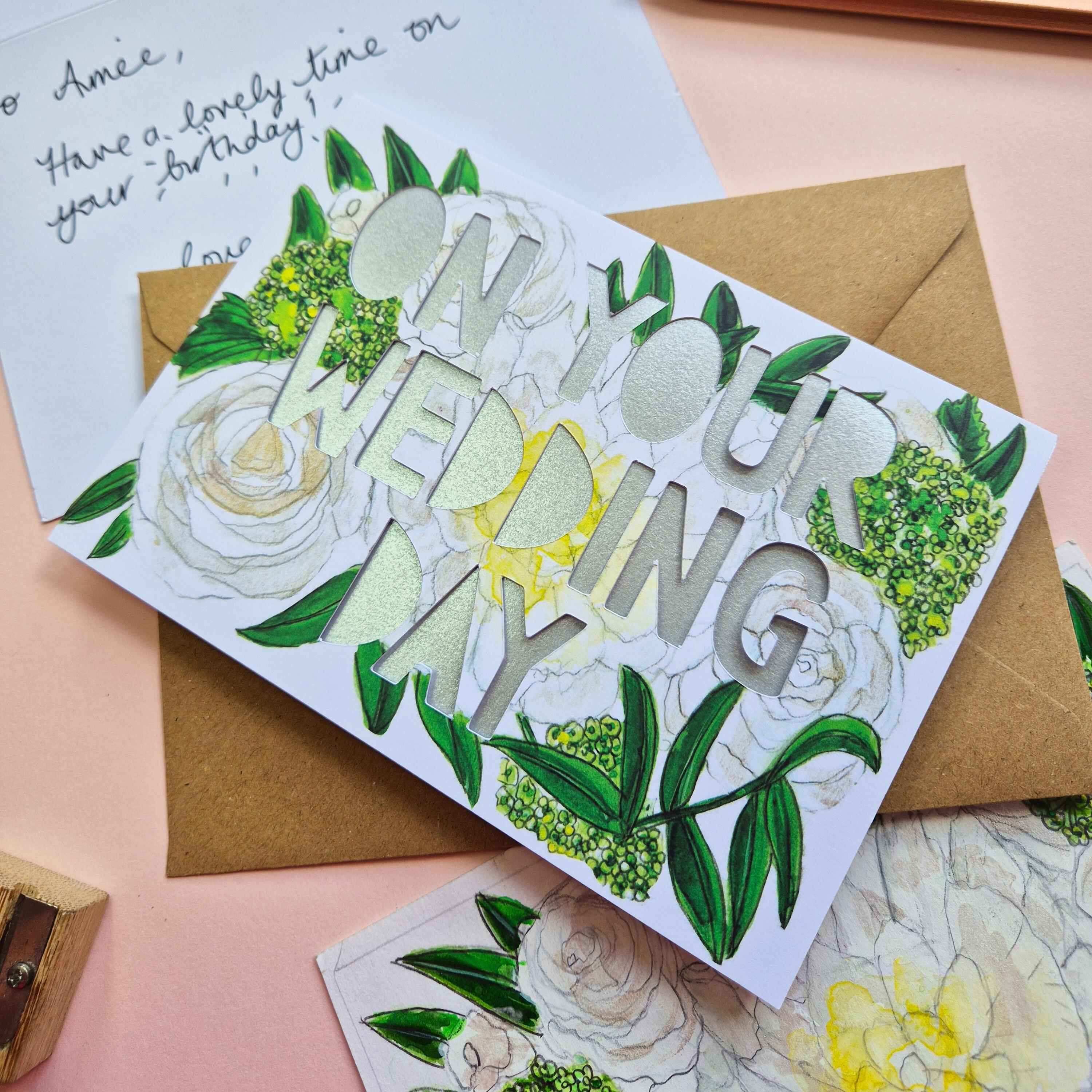 White and green floral illustration card with On Your Wedding Day die cut text and shimmering silver backing paper liner