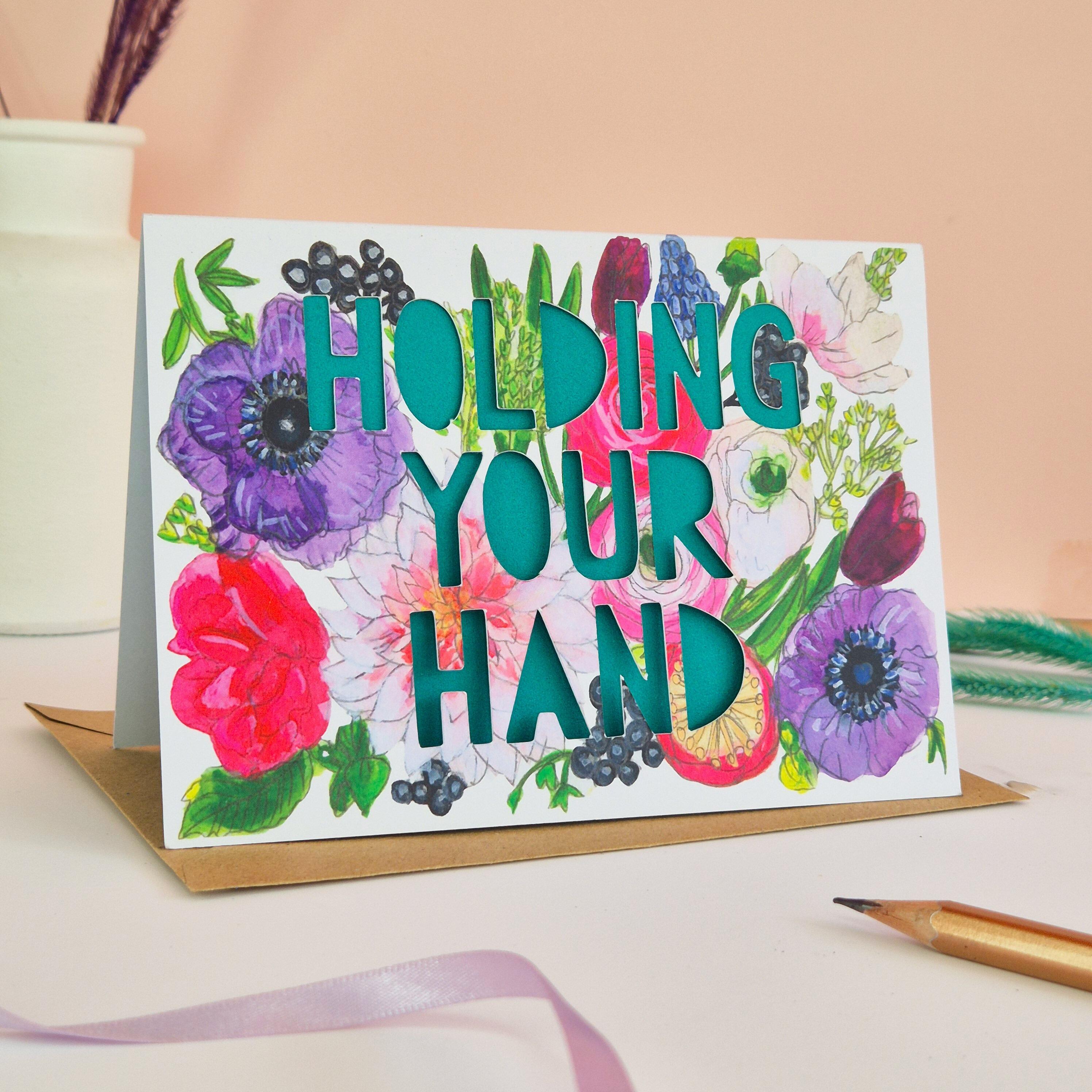 Bright floral illustration card with Holding Your Hand paper cut text and green paper liner