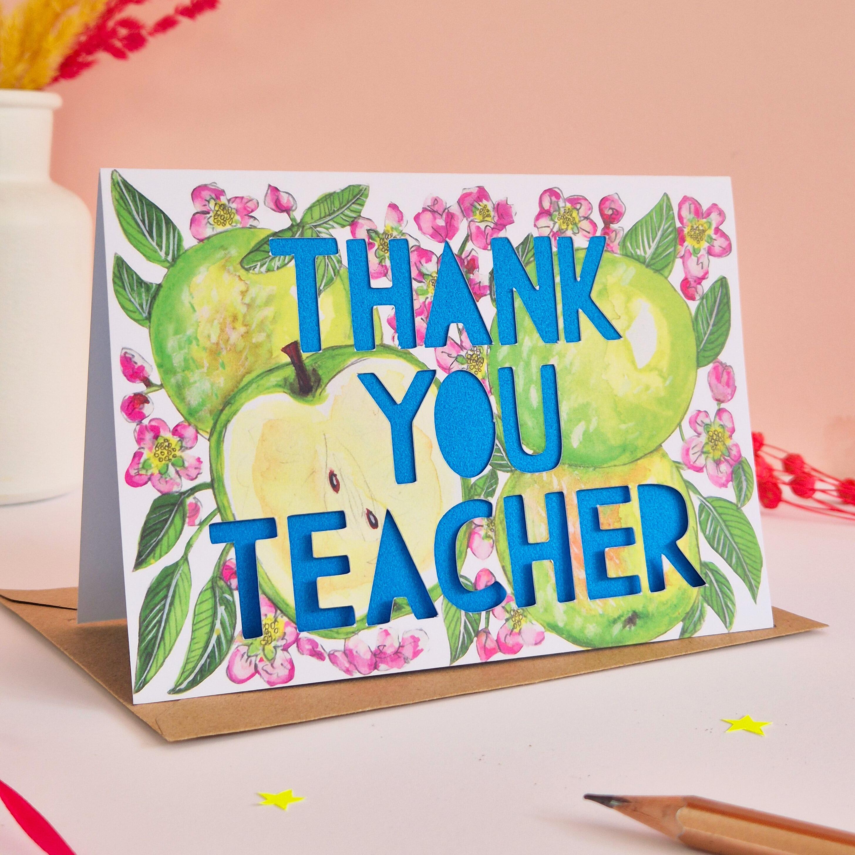 Floral and apple illustration with Thank You teacher paper cut text and bright blue backing paper